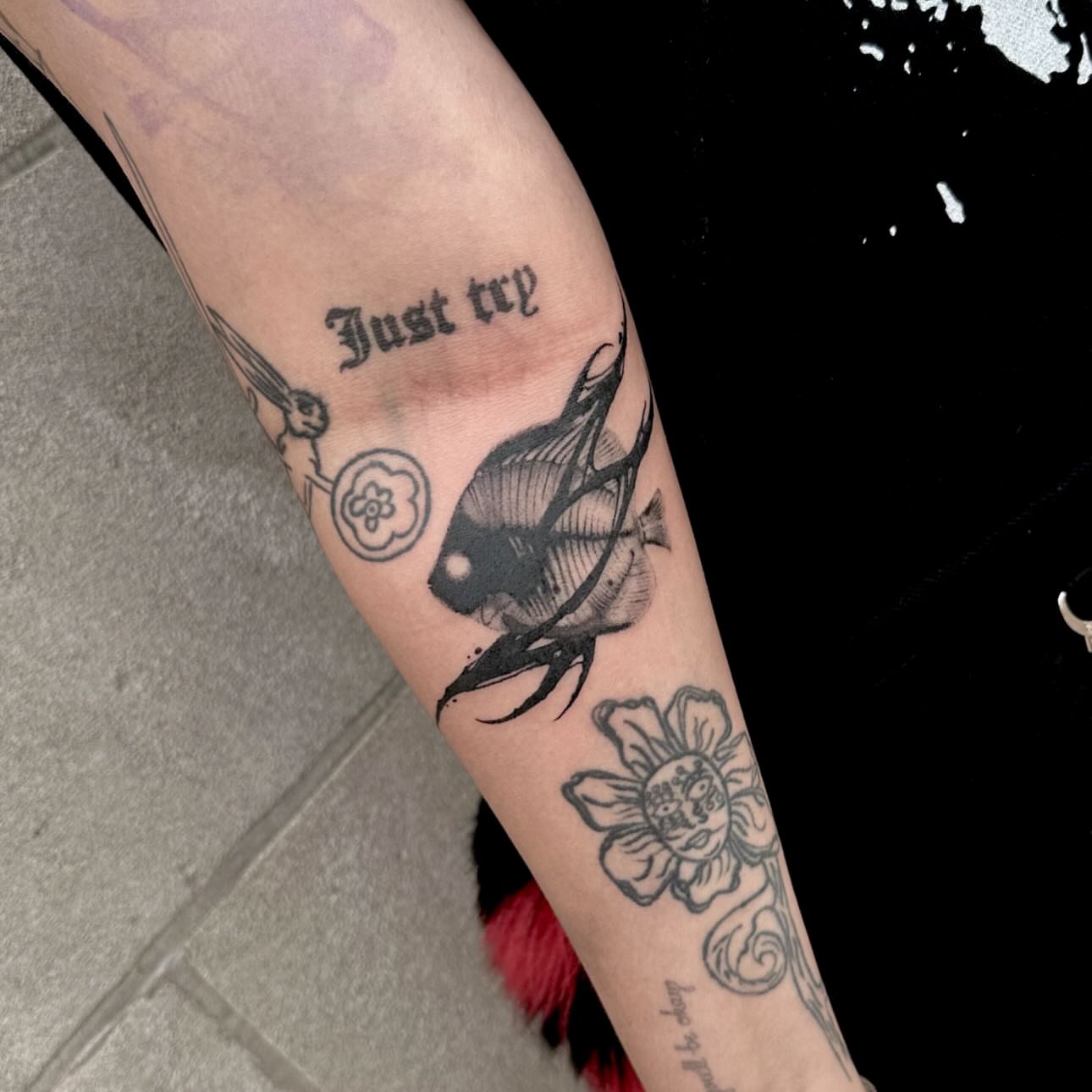 Fish and flower black and grey tattoo on the forearm by Abigail Rae