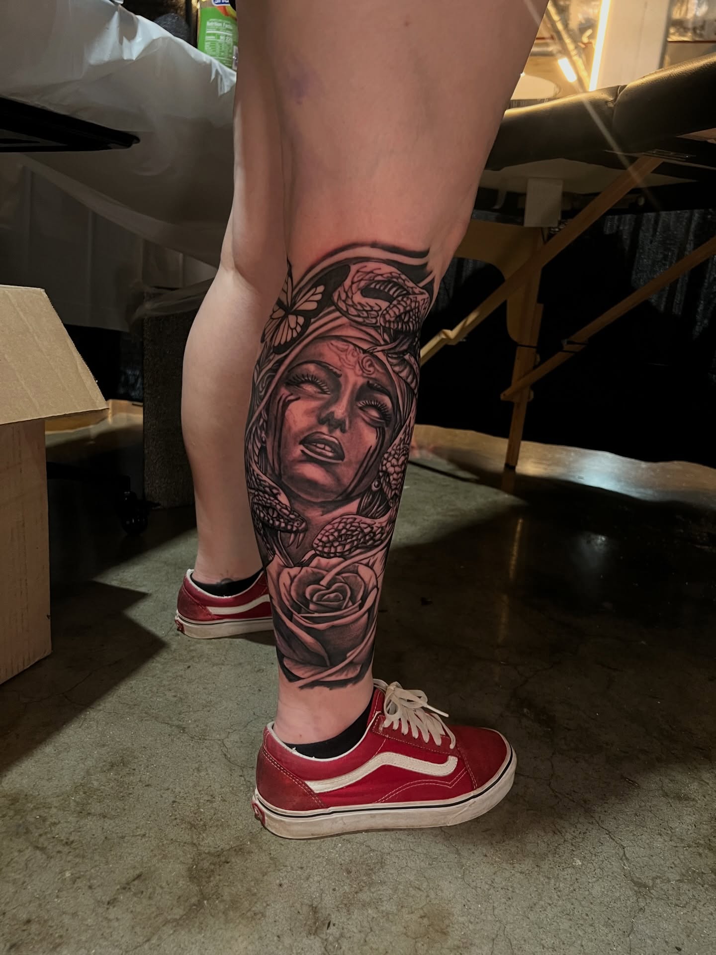 Woman's face realism tattoo on the calf by Dee