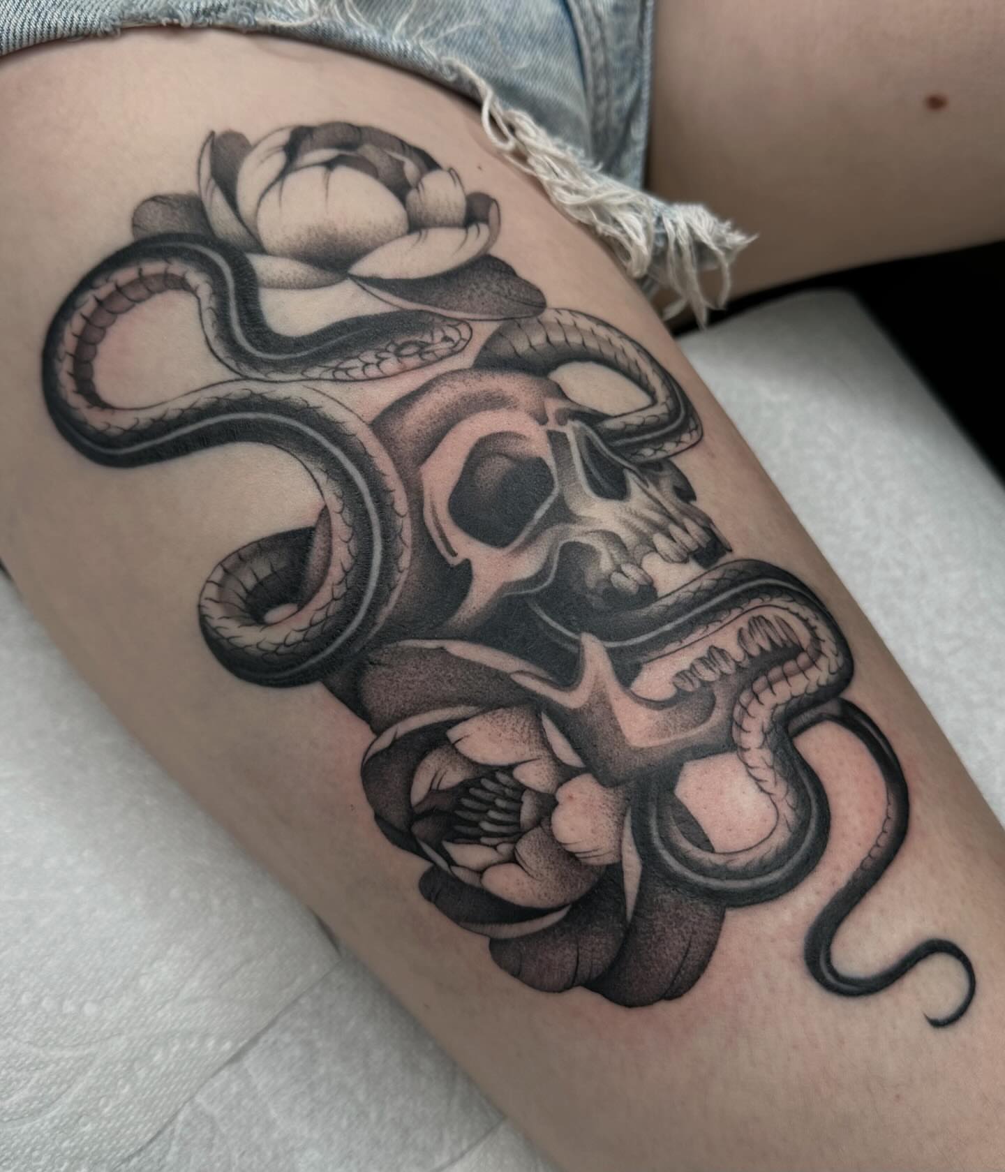 Skull and snakes realism tattoo on the thigh by Aleksandra