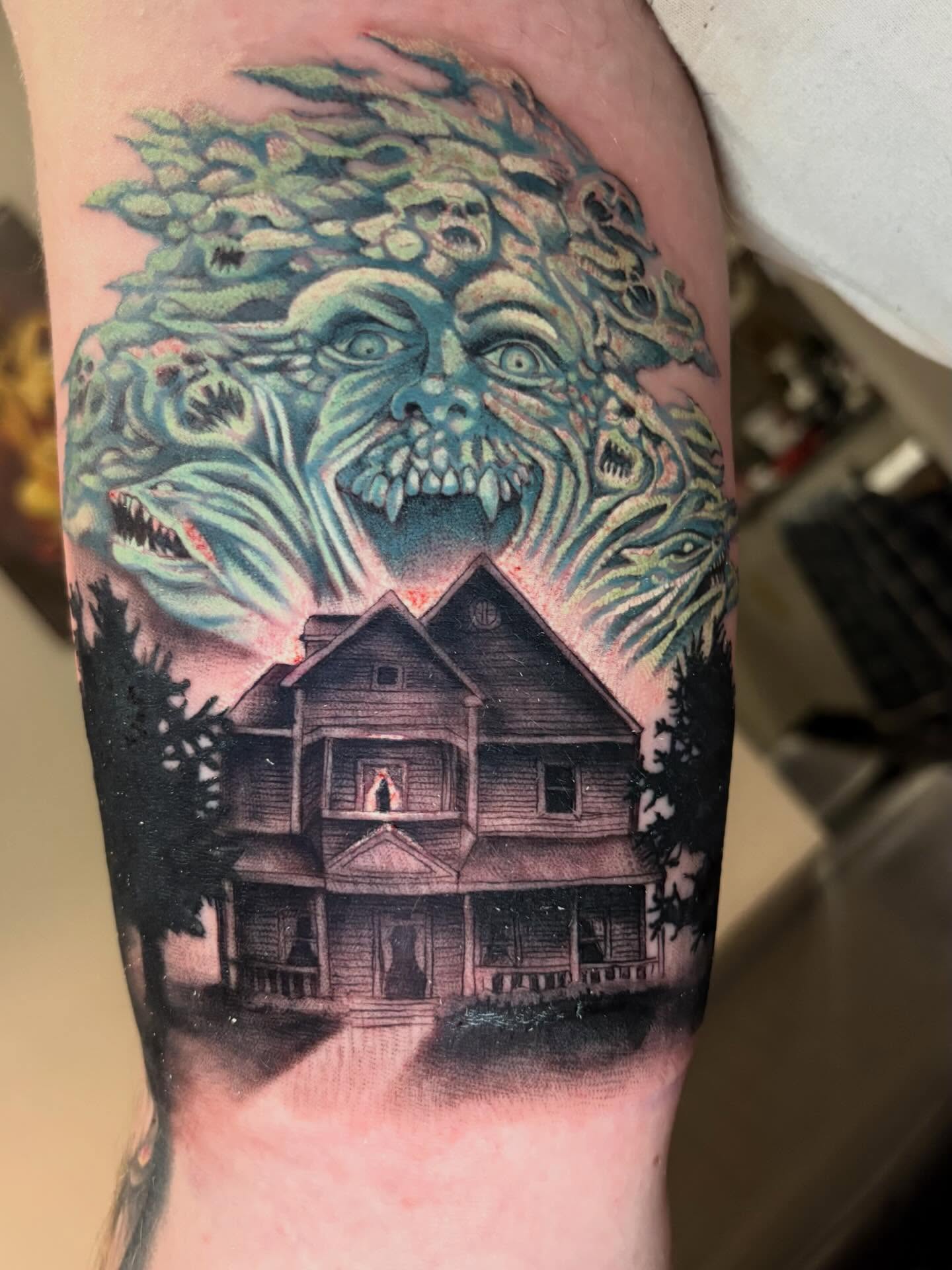 House with tree-like creature dark realism tattoo on the forearm by Eddie Wolfe