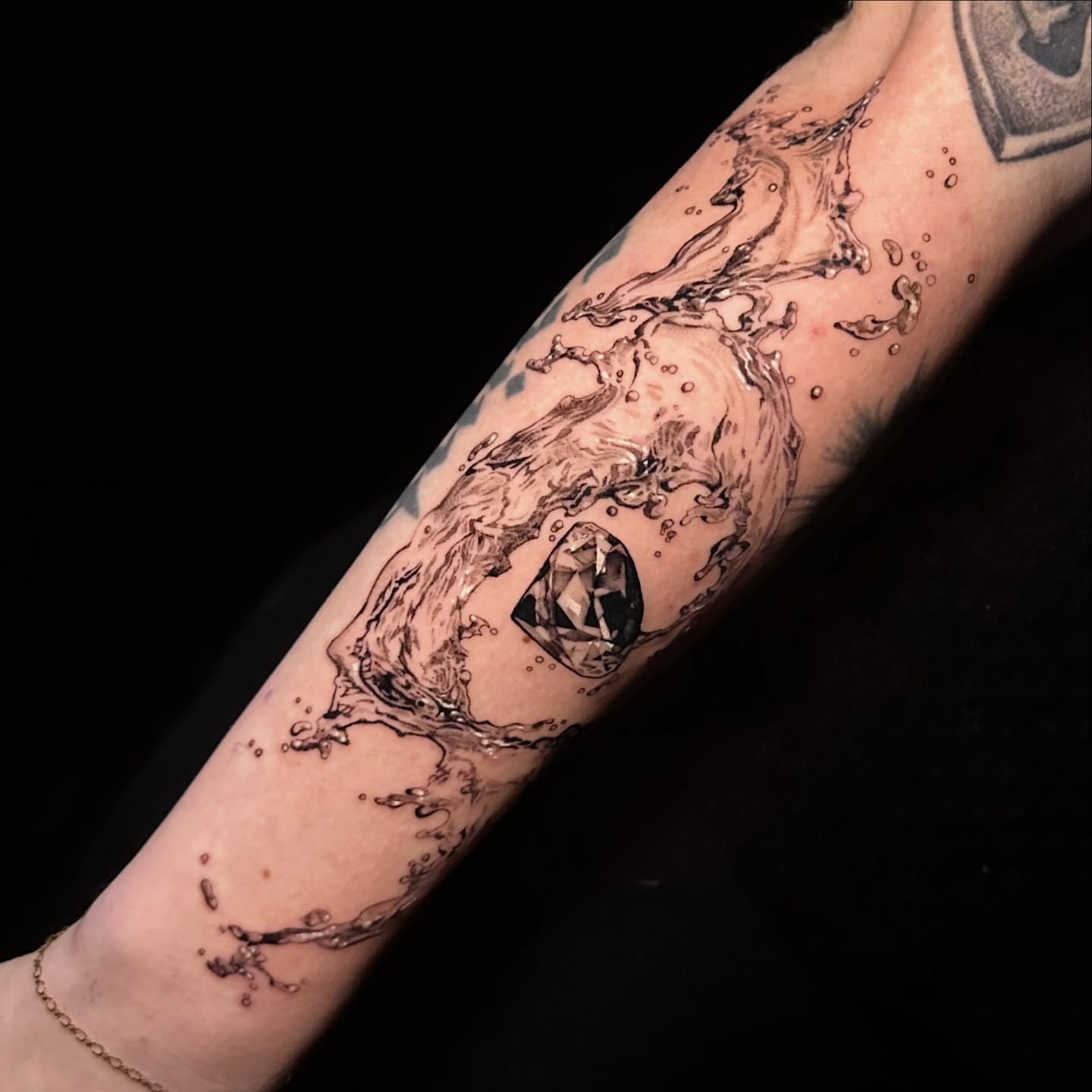 Water splash realism tattoo on the forearm by Breah Beshore Kirk