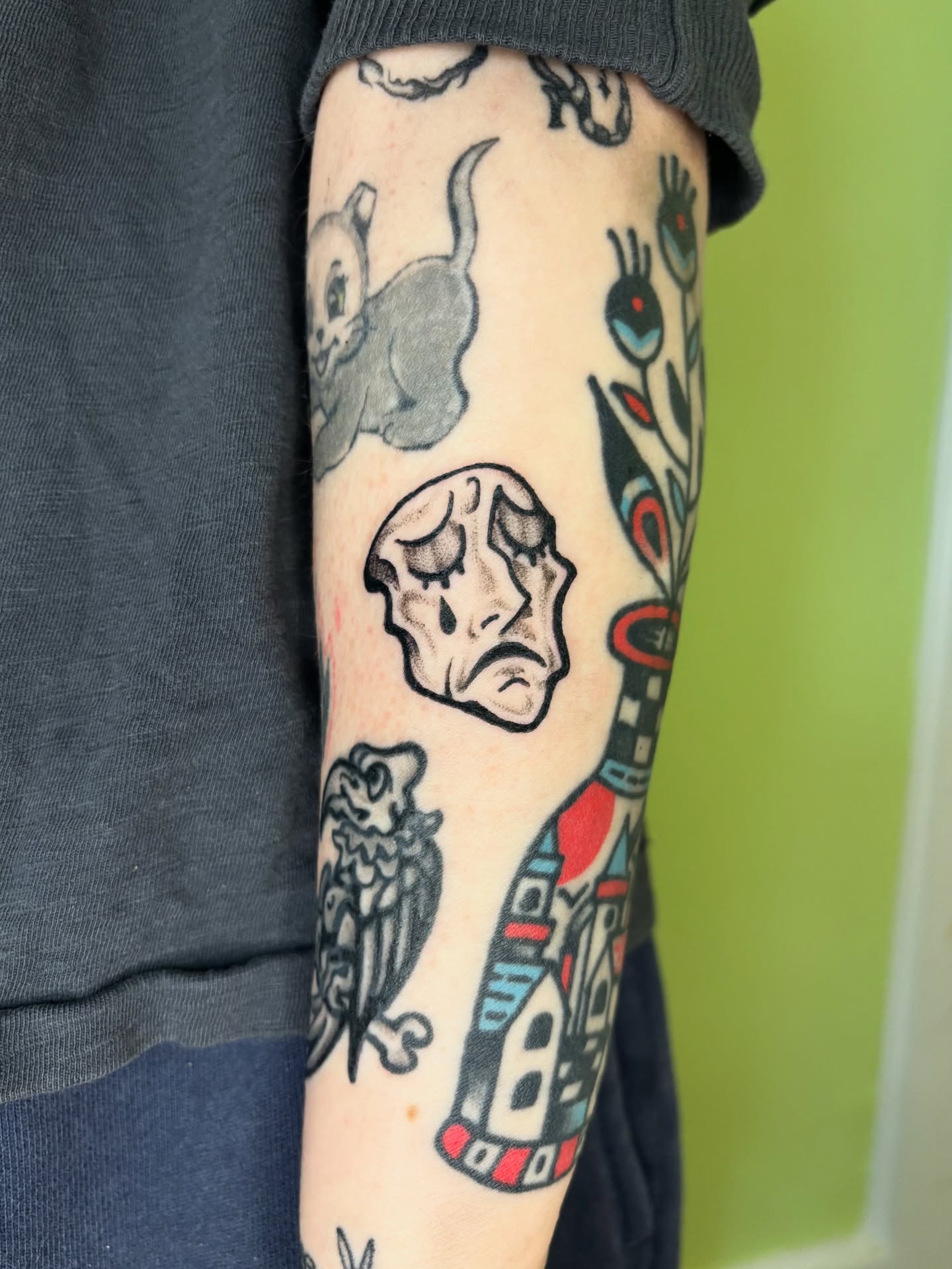 Sad skull American traditional tattoo on the forearm by Grae