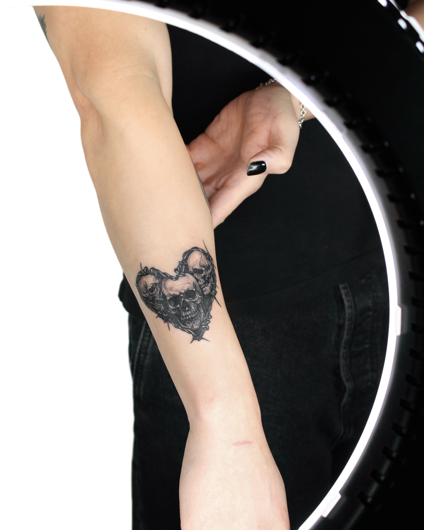 Skulls and heart black and grey tattoo on the forearm by Tatmostat