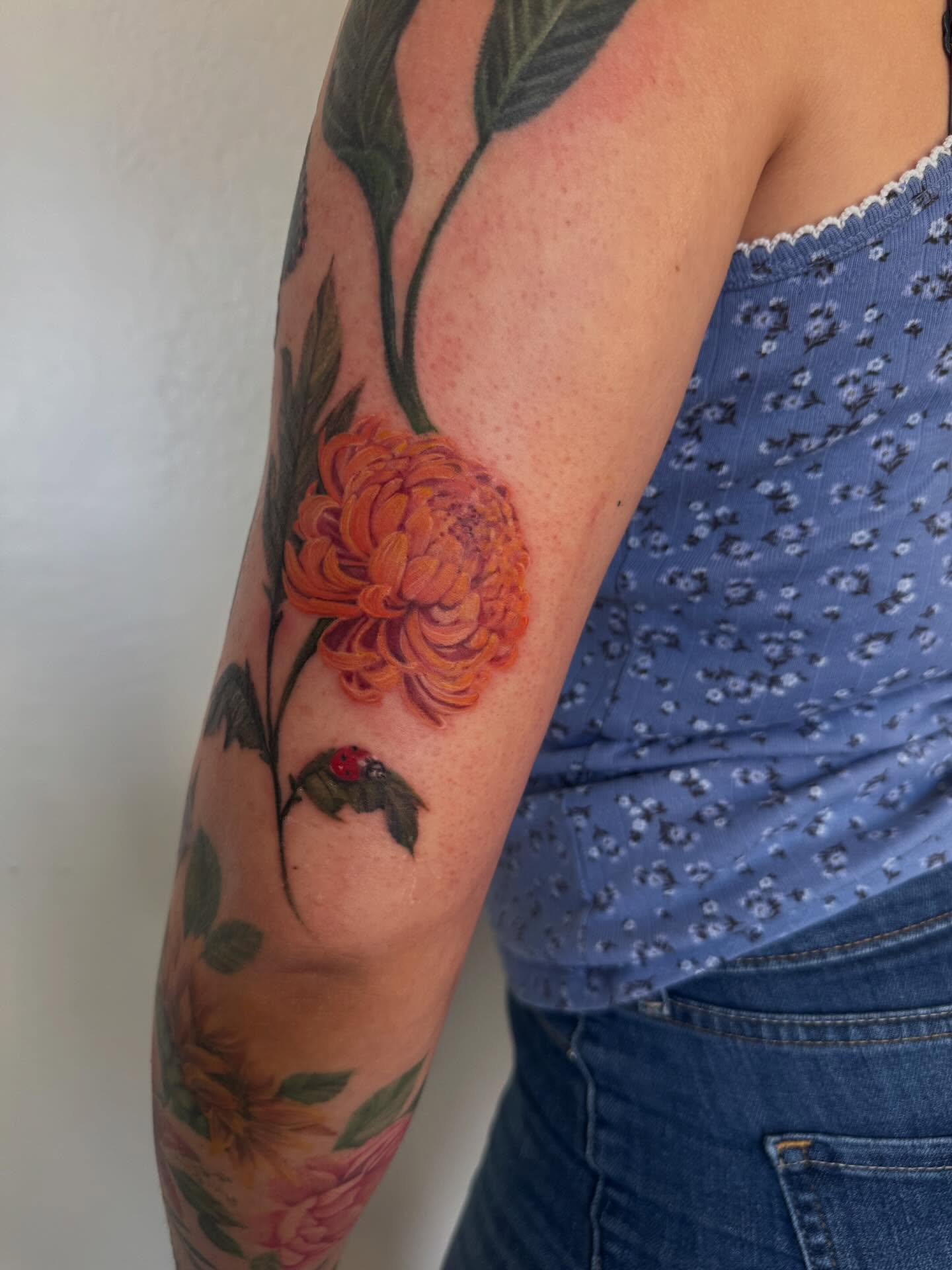 Chrysanthemum realism tattoo on the forearm by Tianna Osborne