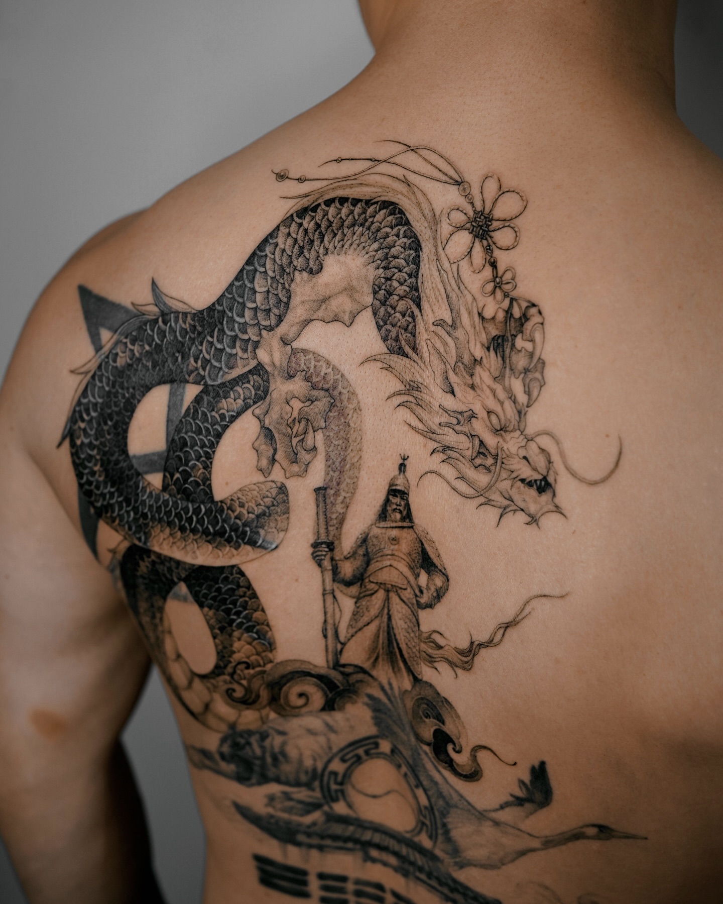 Dragon and warrior realism tattoo on the back by Yeonji