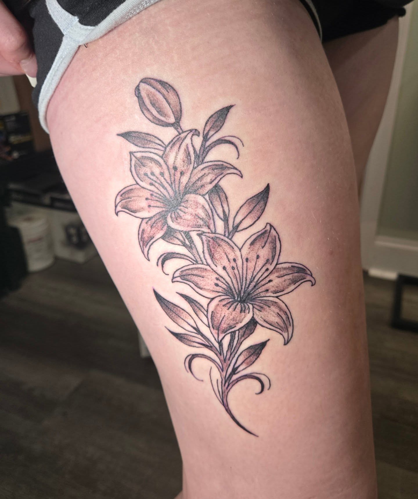 Lilies black and grey tattoo on the thigh by Matt Page