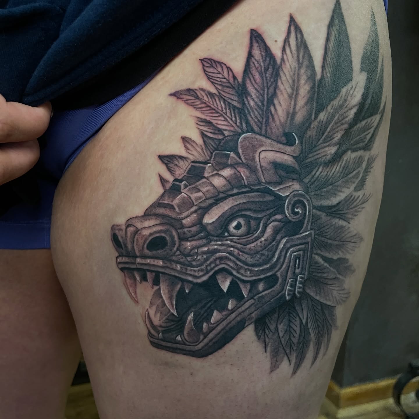 Serpent mask black and grey tattoo on the thigh by Zachary Hayden
