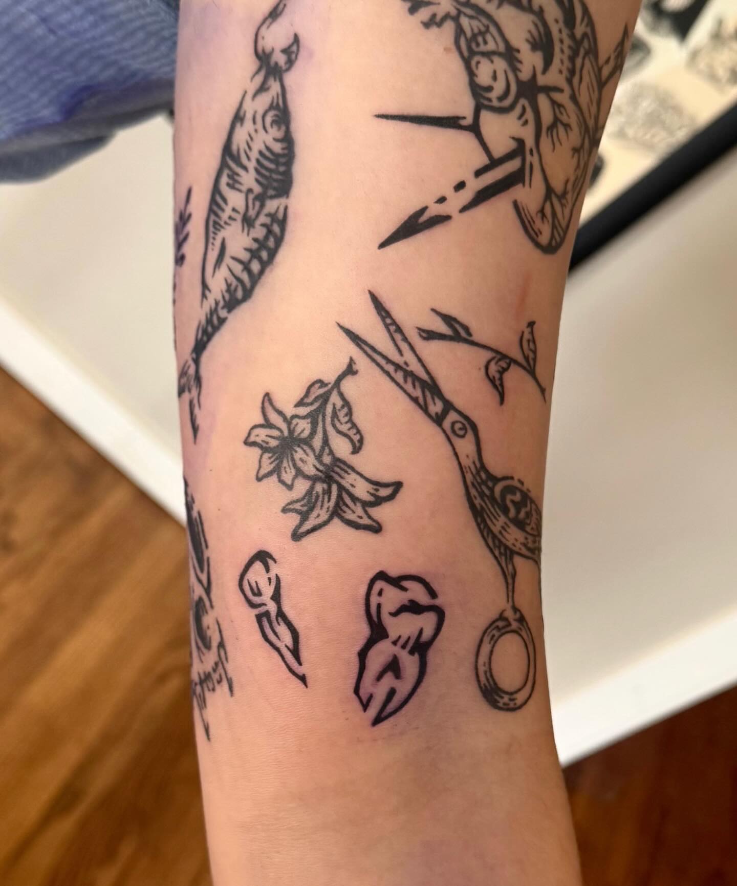 Scissors and flowers black and grey tattoo on the forearm by M