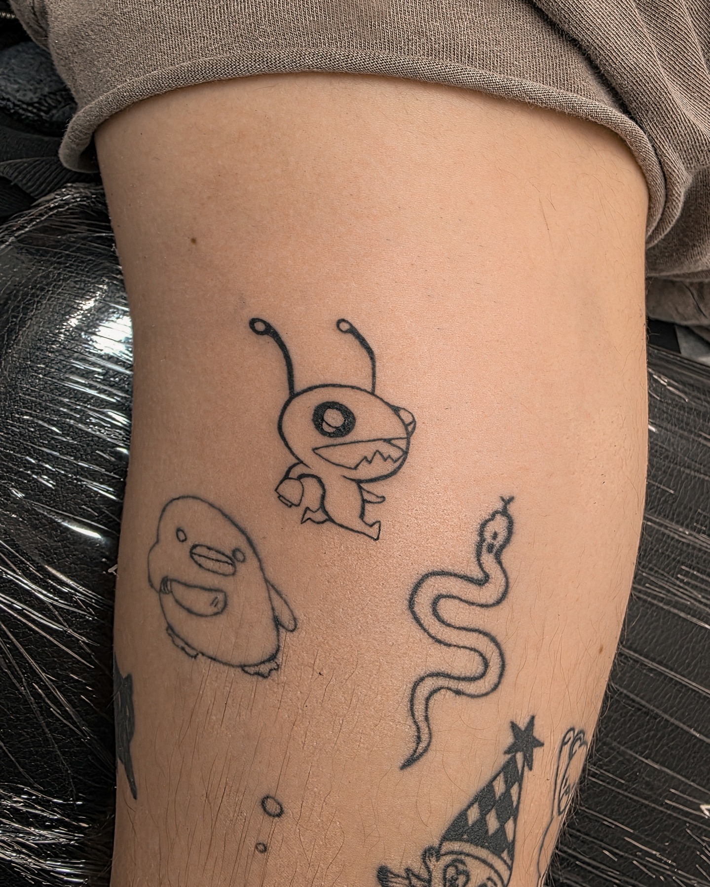 Monster trio black and grey tattoo on the thigh by Richmond tattoo shop, Richmond, Texas