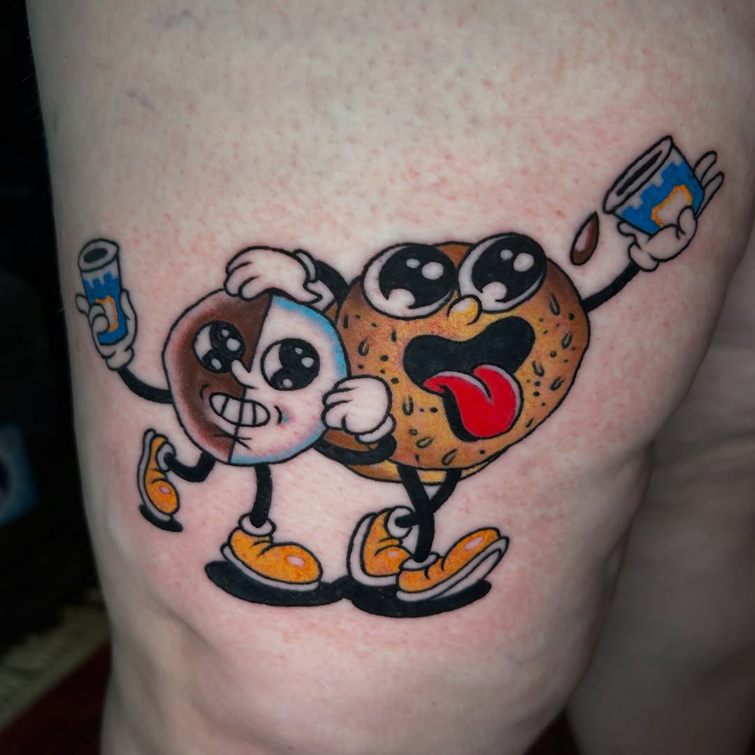 Cartoon donut and cookie ignorant tattoo on the thigh by Olivia Marie
