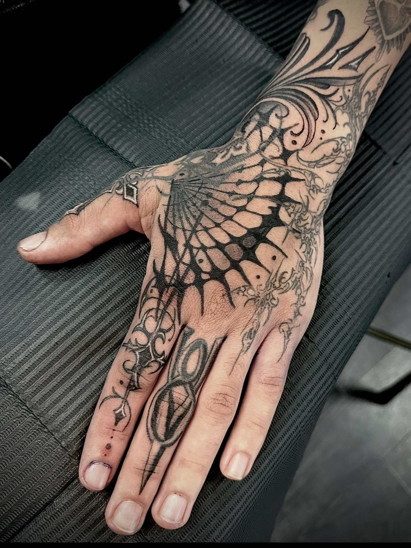 Spider web geometric tattoo on the hand by Javier Rivera