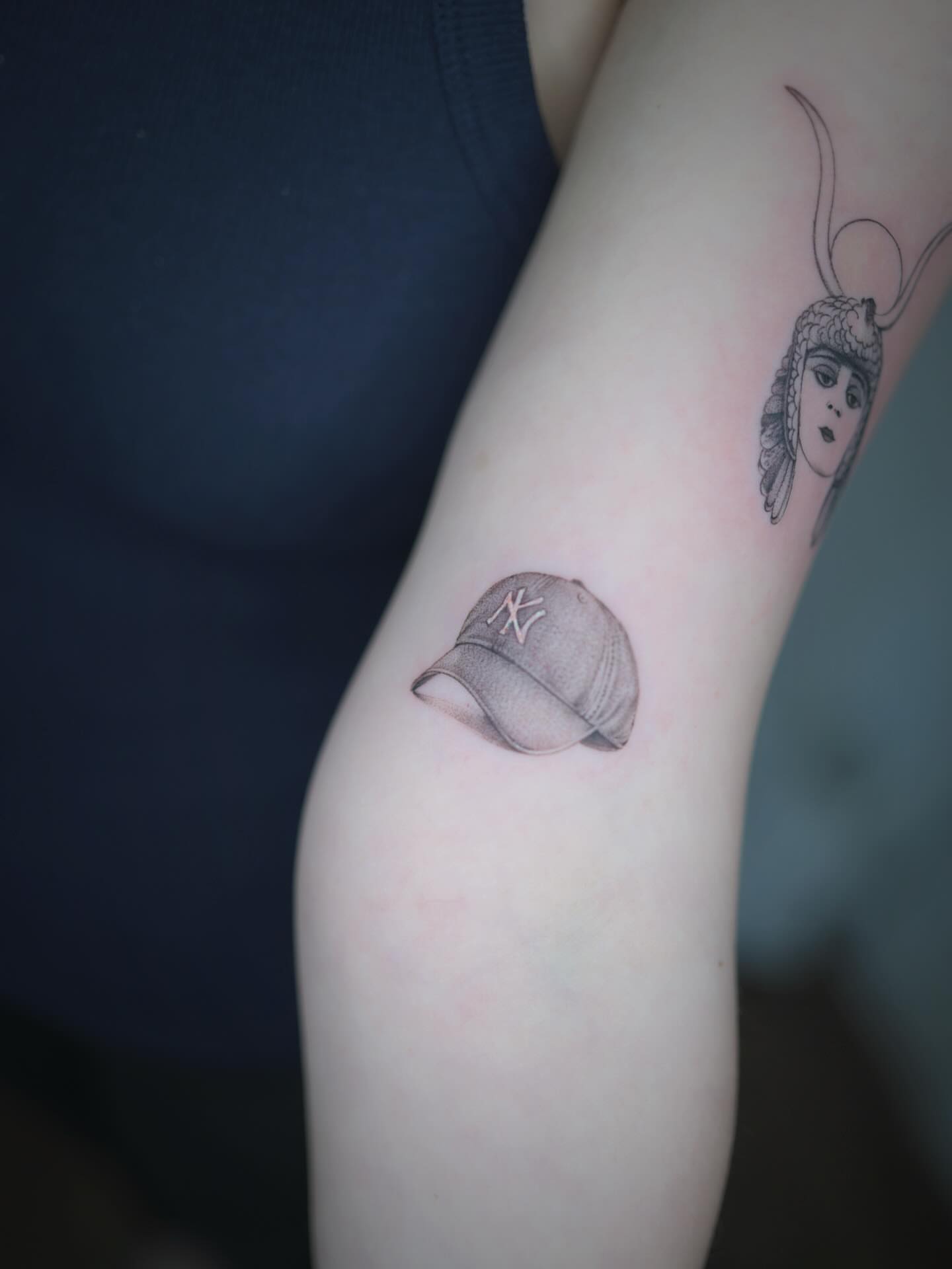 Baseball cap black and grey tattoo on the forearm by Seattle tattoo artist-Mia