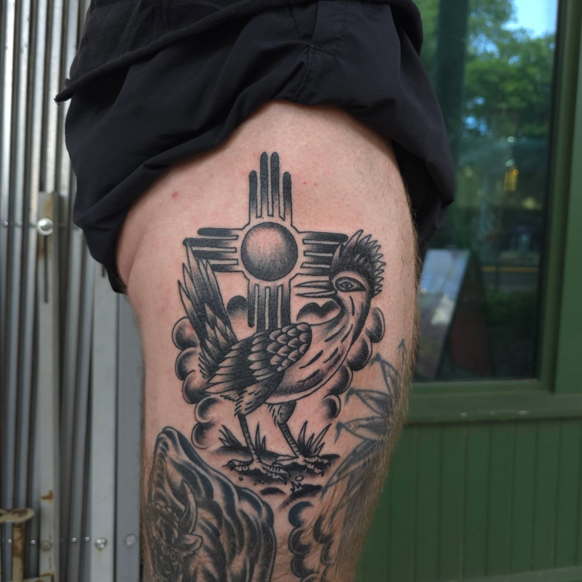 Sun symbol with bird American traditional tattoo on the thigh by Jared Green