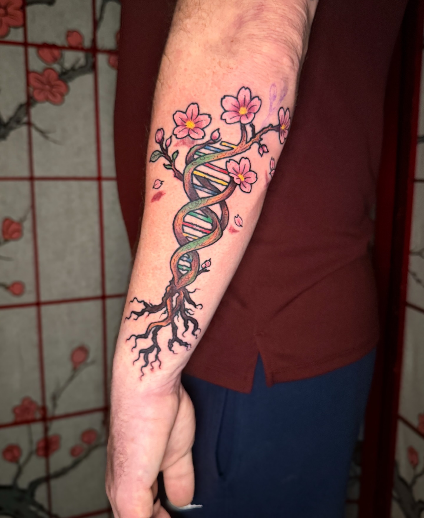 DNA strand with cherry blossoms new school tattoo on the forearm by Ty Hamilton