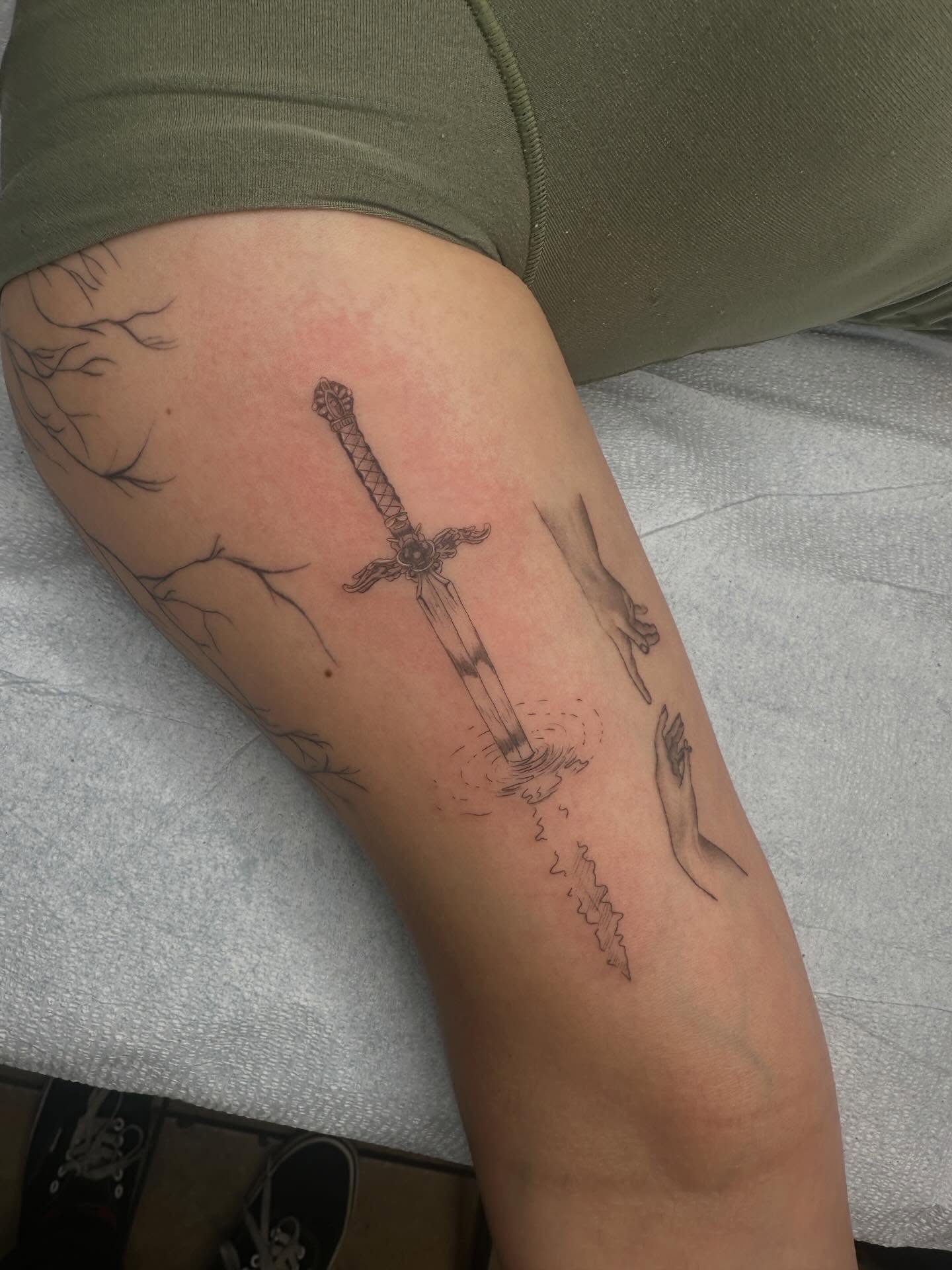 Sword and hands black and grey tattoo on the forearm by Alex Gunshefski