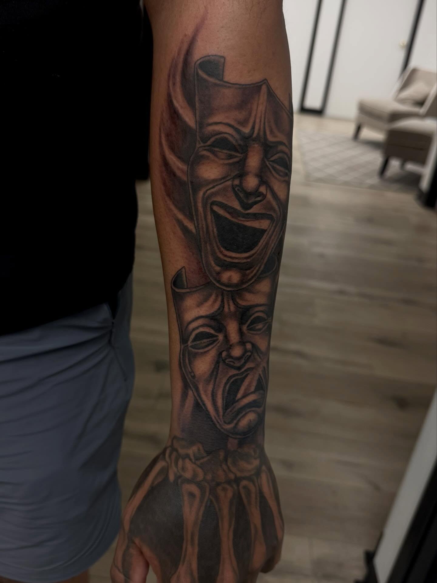Mask black and grey tattoo on the forearm by Gigi