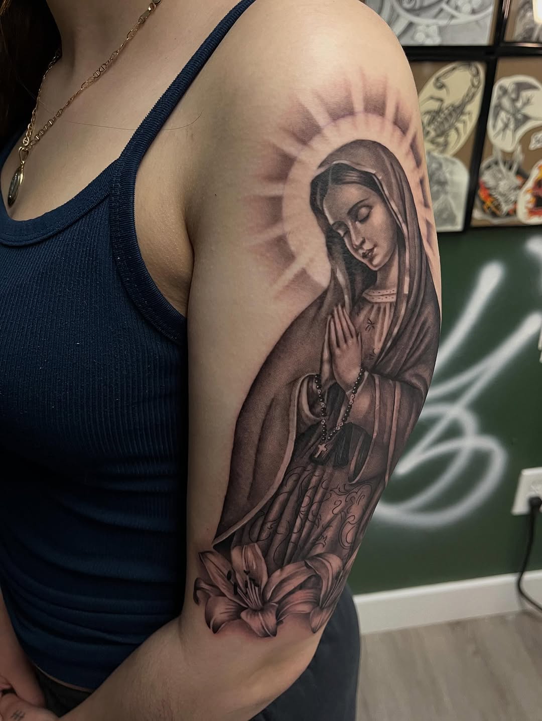 Virgin Mary with lily Chicano tattoo on the upper arm by Denver Tattoo Artist