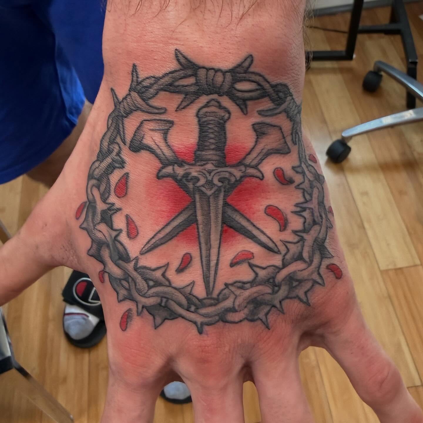 Sword and crown of thorns black and grey tattoo on the thigh by Tony Beuke