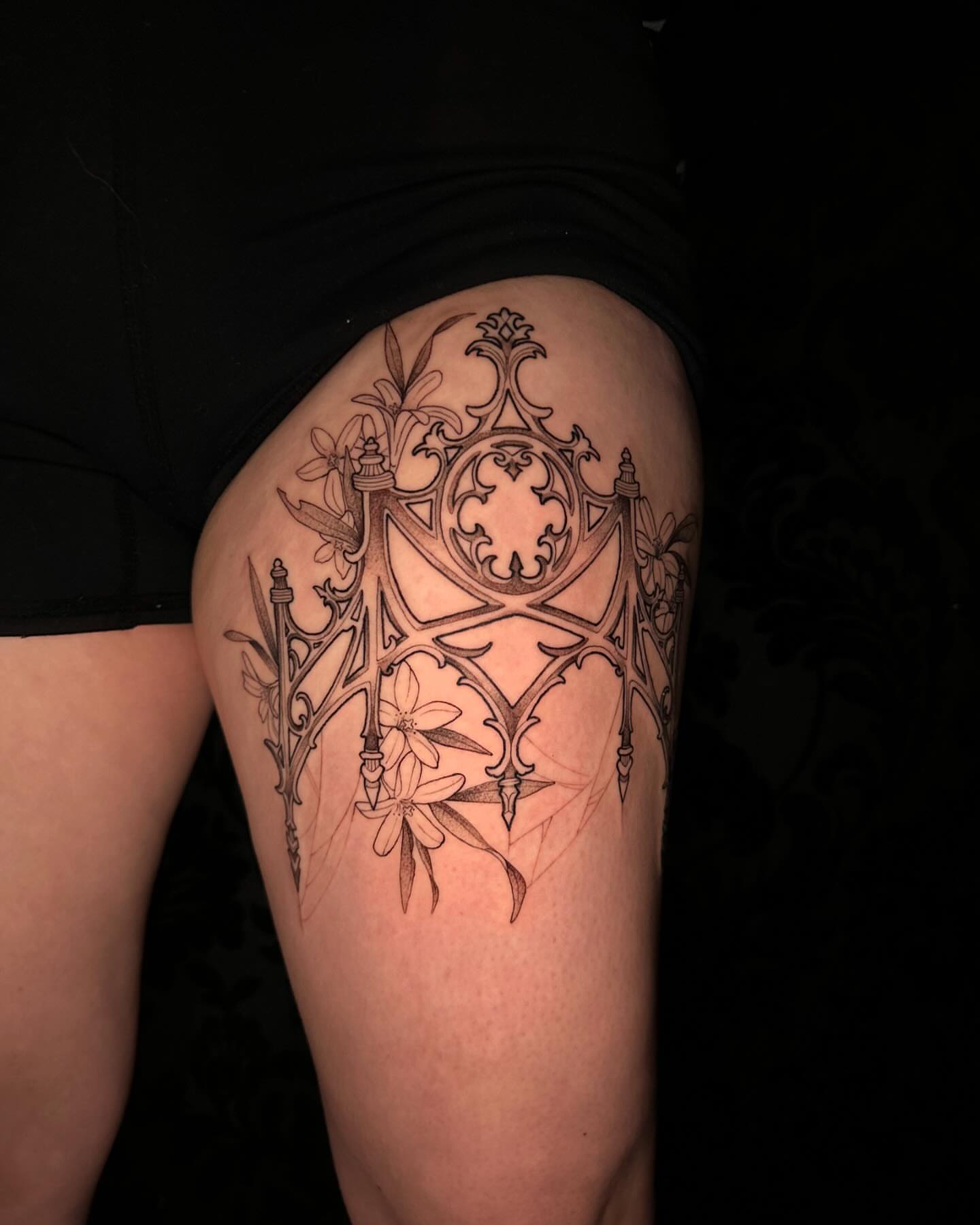 Gothic arches and flowers ornamental tattoo on the thigh by Cassandra Rasper-Beard