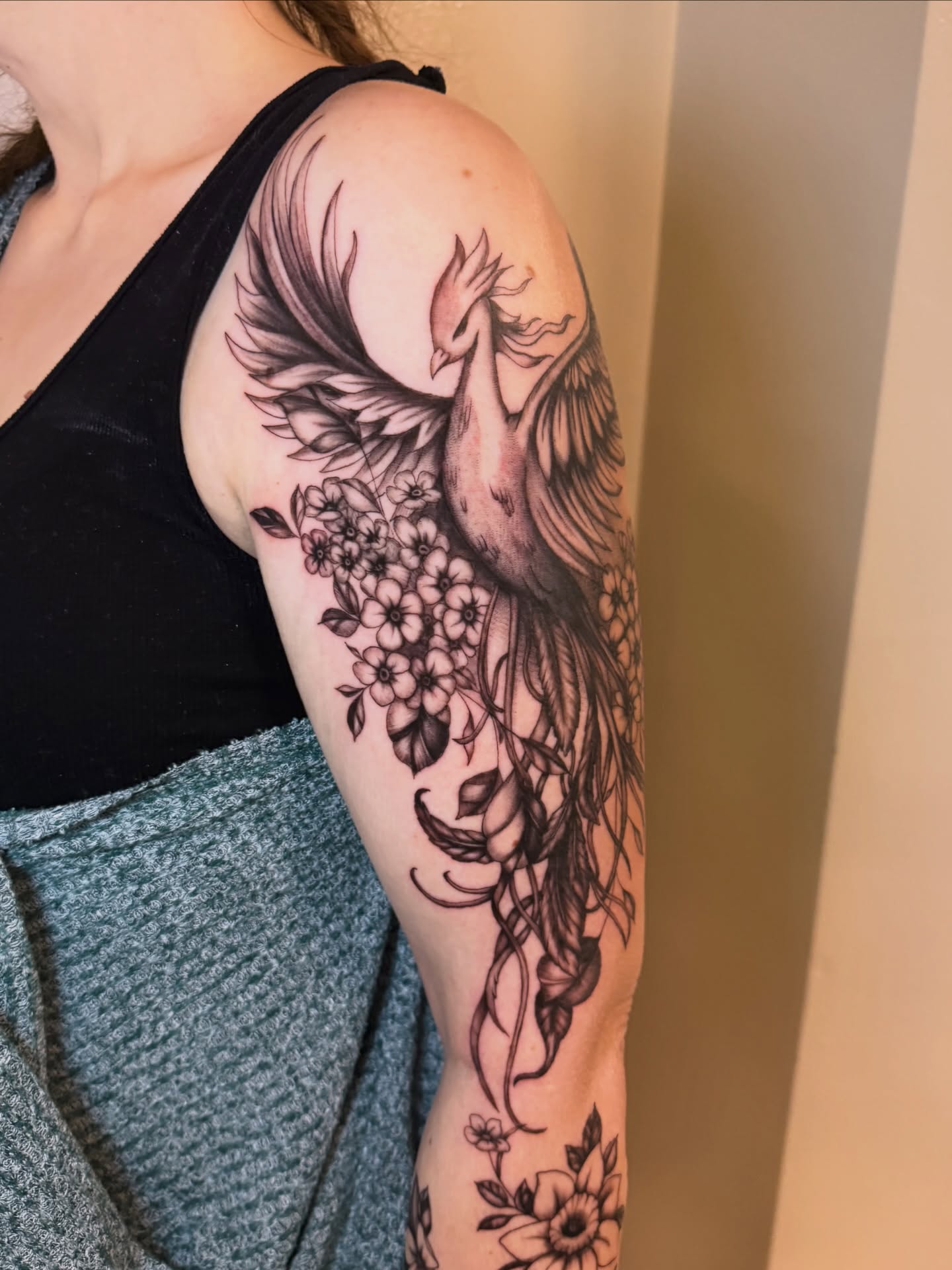 Phoenix and flowers realism tattoo on the upper arm by utah tattoo artist