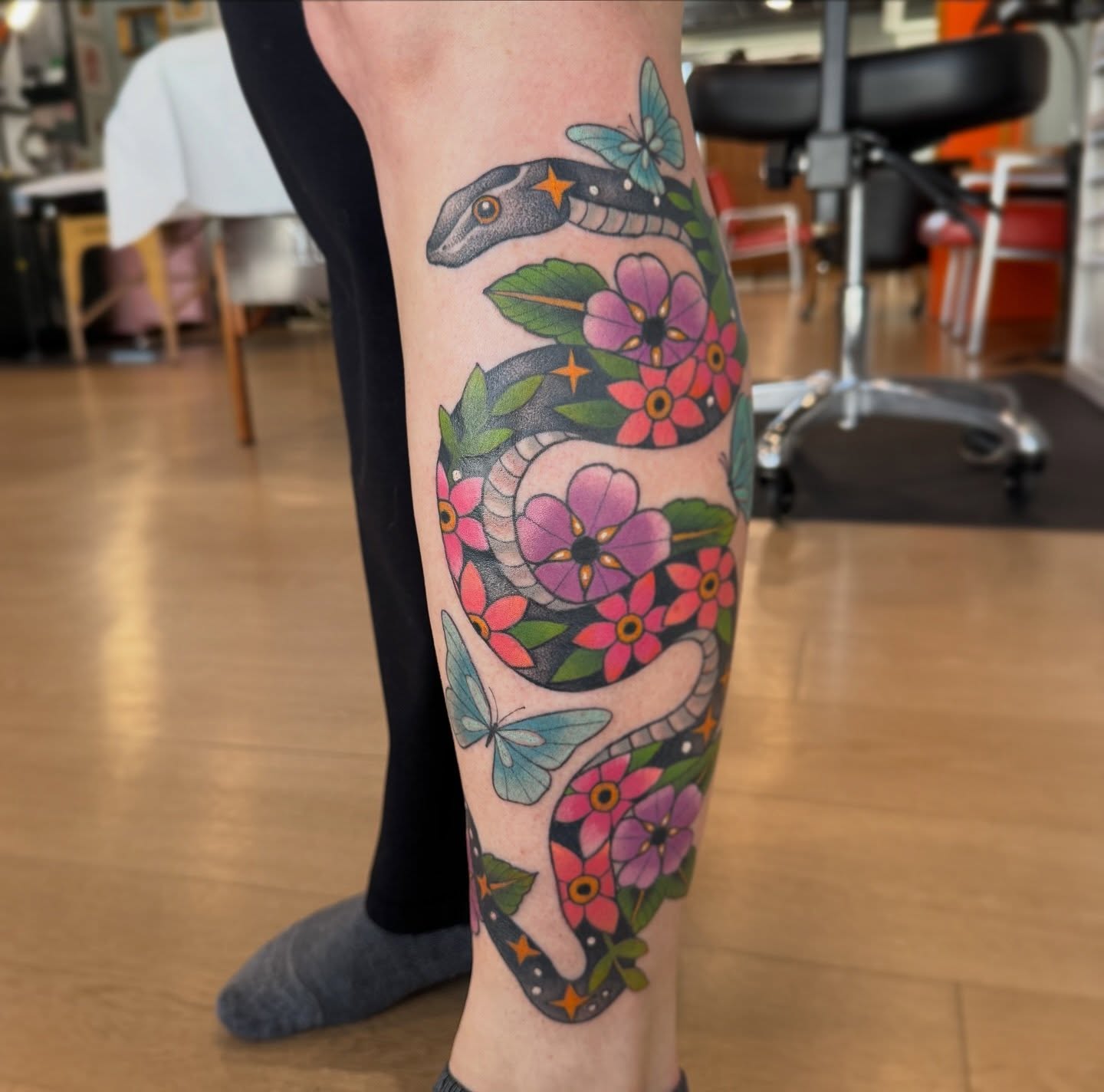 Snake and flowers American traditional tattoo on the calf by Kaley, Des Moines, Iowa