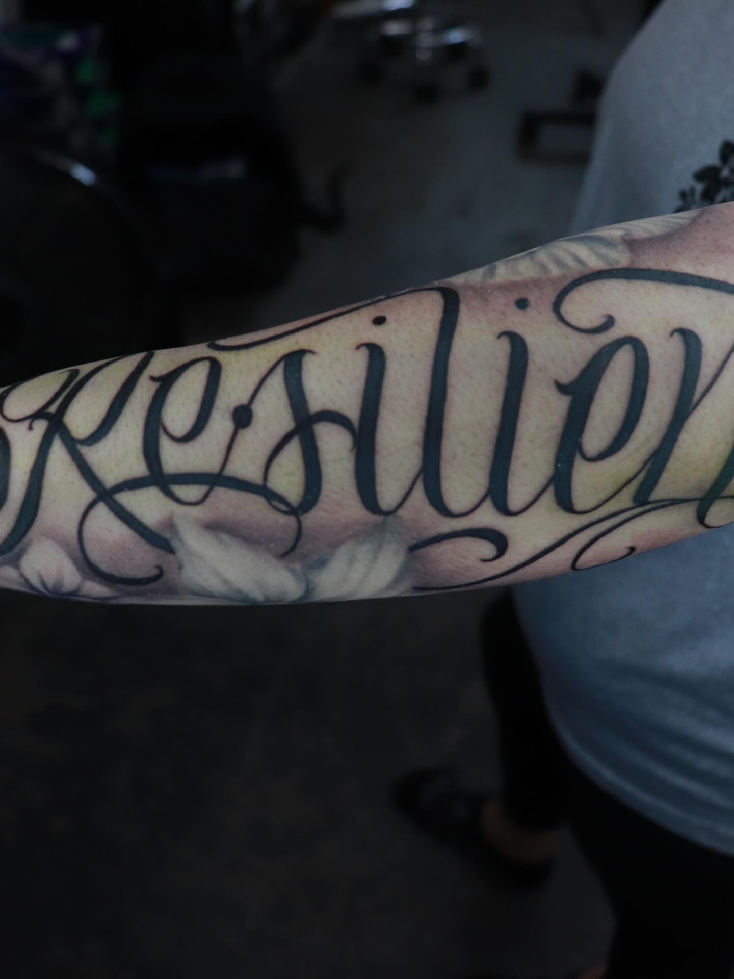 Resilience lettering script tattoo on the forearm by Daniel Rodriguez