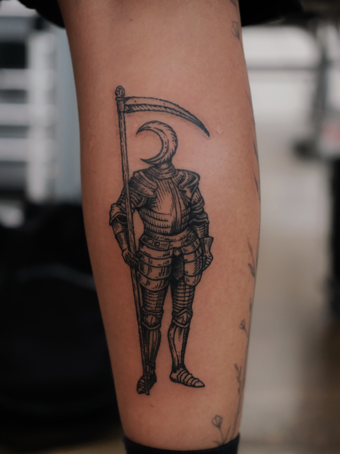 Scythe-wielding knight black and grey tattoo on the forearm by ꜰʟᴏʀᴀ ᴡᴏᴏᴅᴄᴜᴛ ᴛᴀᴛᴛᴏᴏ
