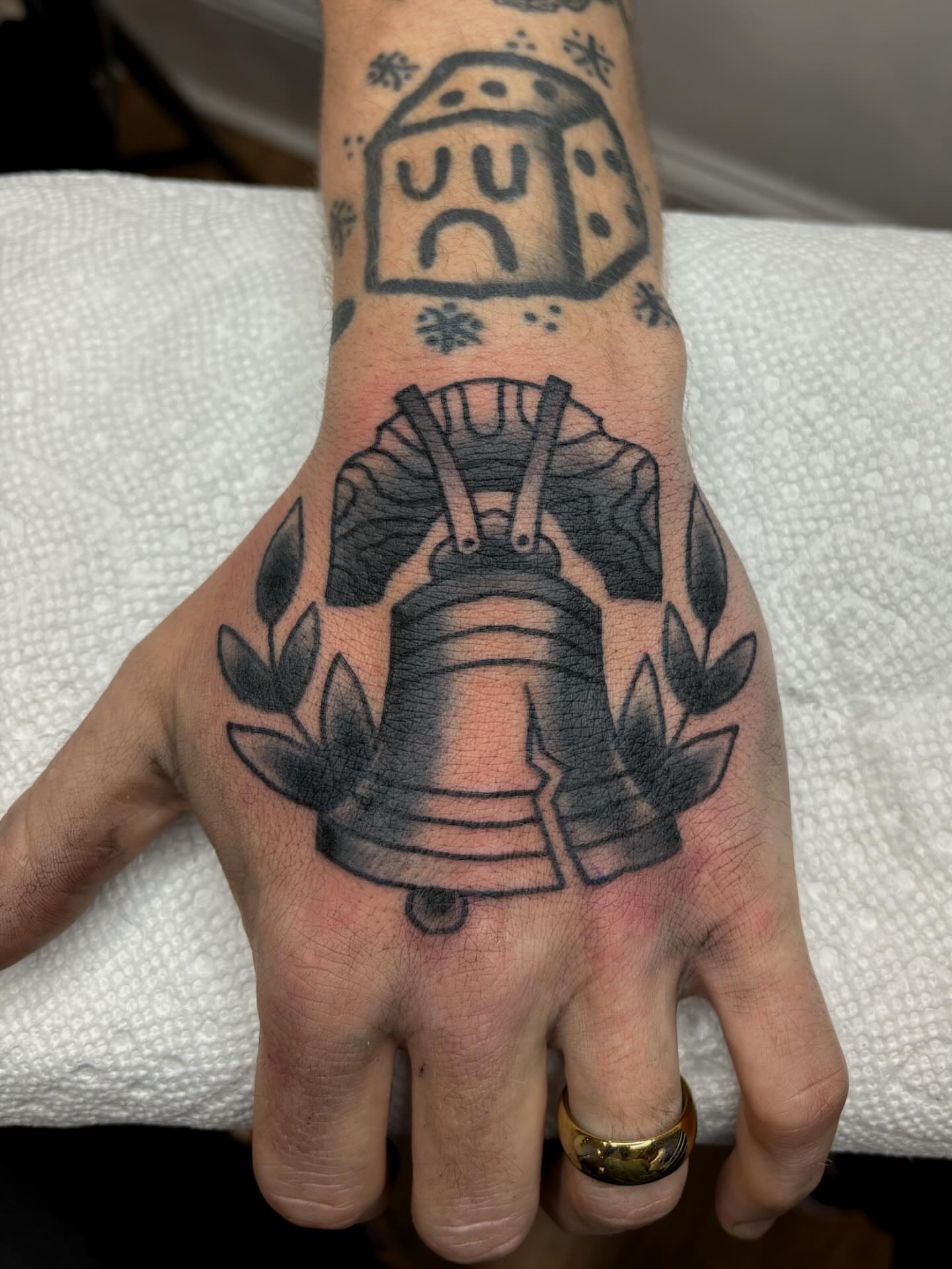 Bell black and grey tattoo on the hand by Evan Bisso, Philadelphia, Pennsylvania