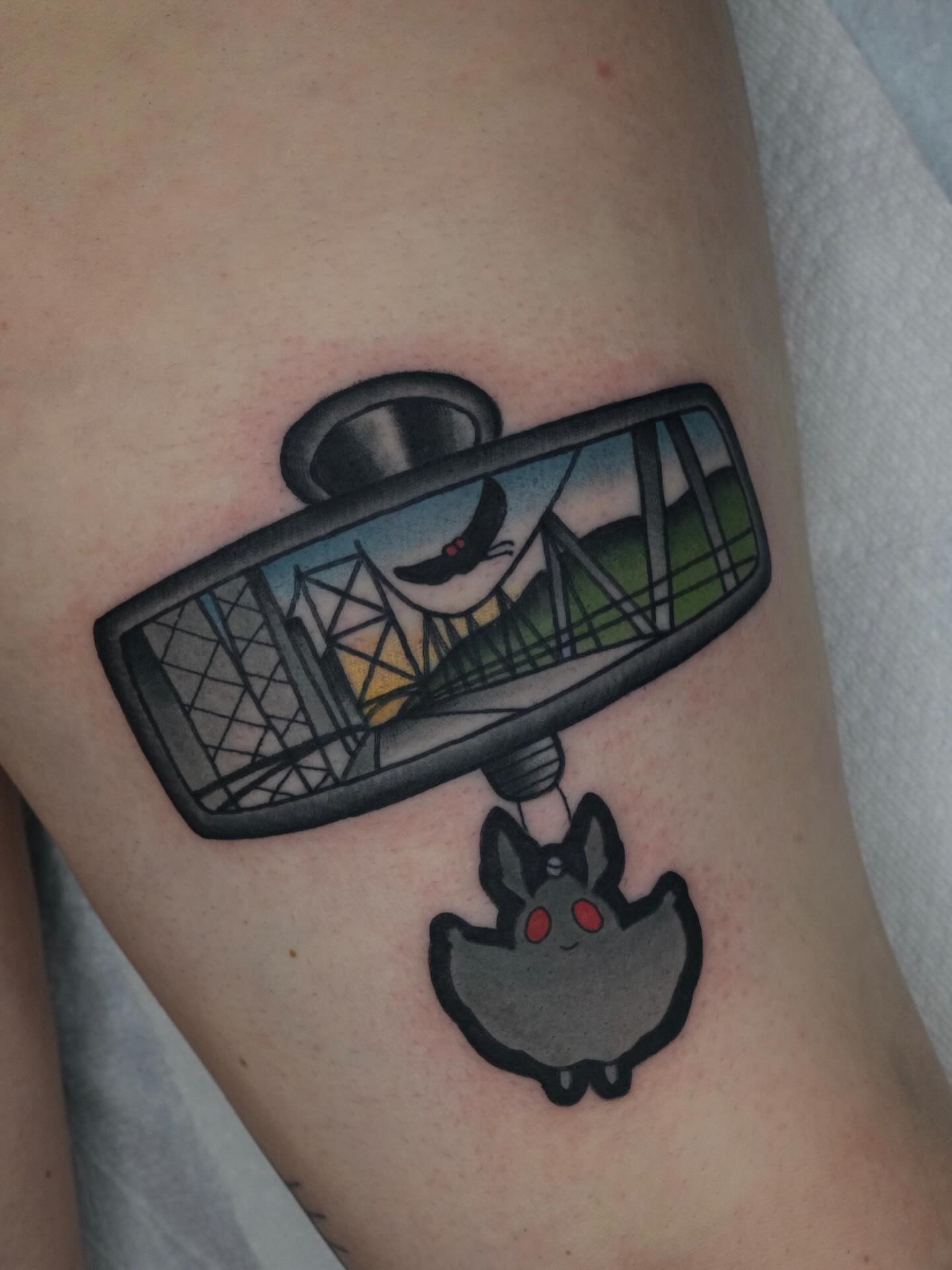Rearview mirror with cat American traditional tattoo on the forearm by James Maxwell