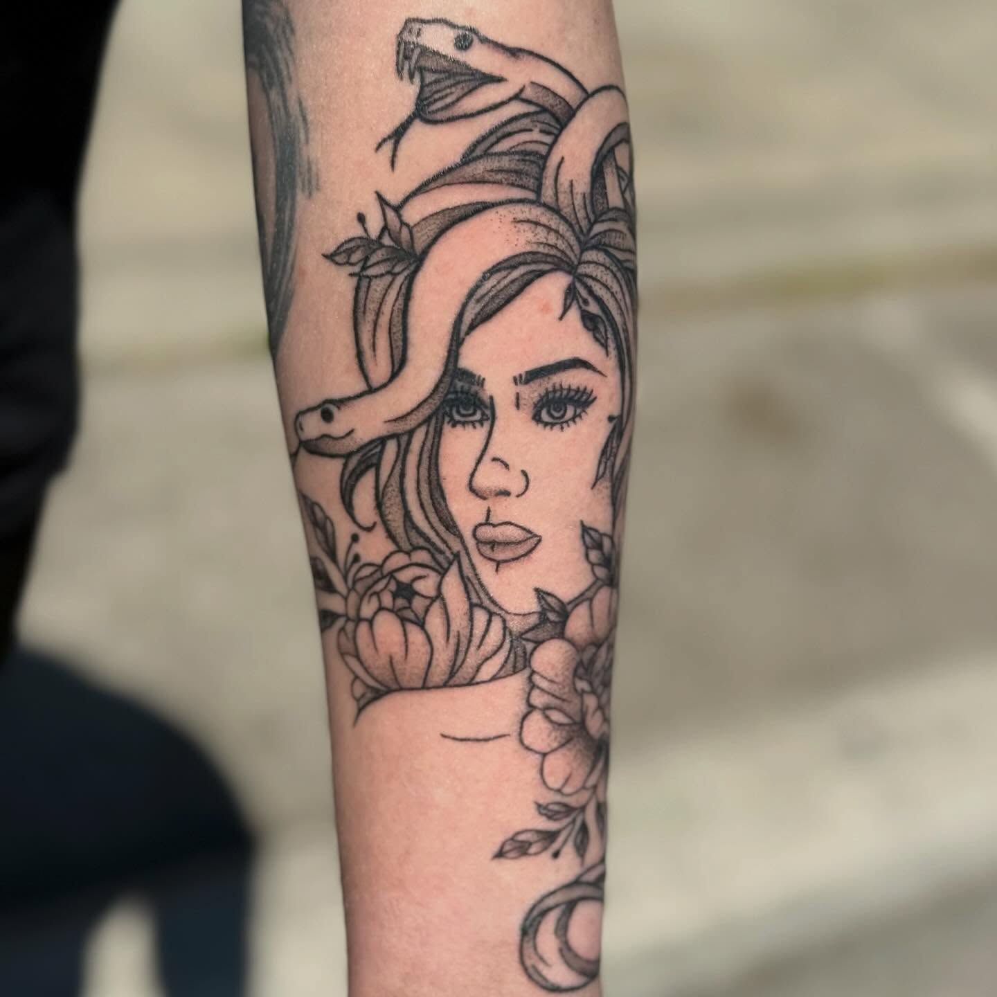 Woman with snake black and grey tattoo on the forearm by zoie rozay hannah