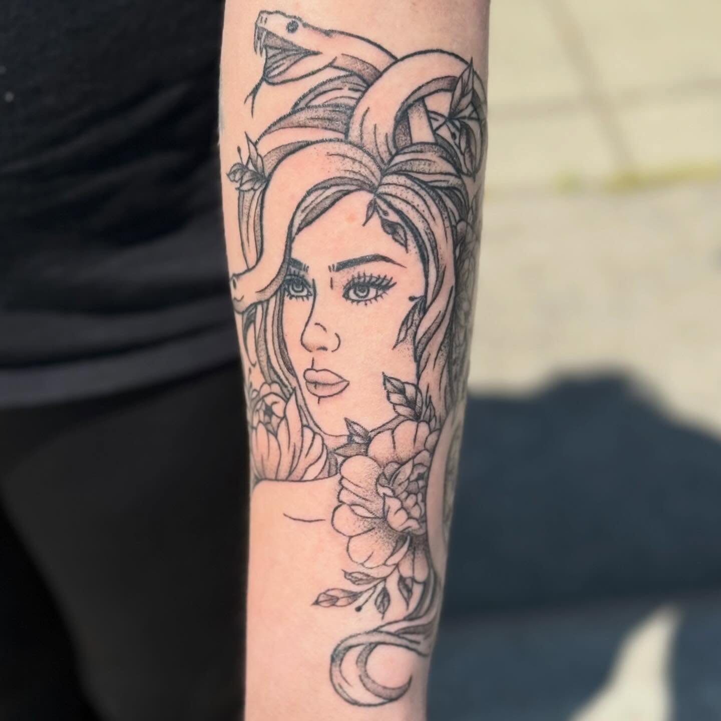 Woman with snakes black and grey tattoo on the forearm by zoie rozay hannah