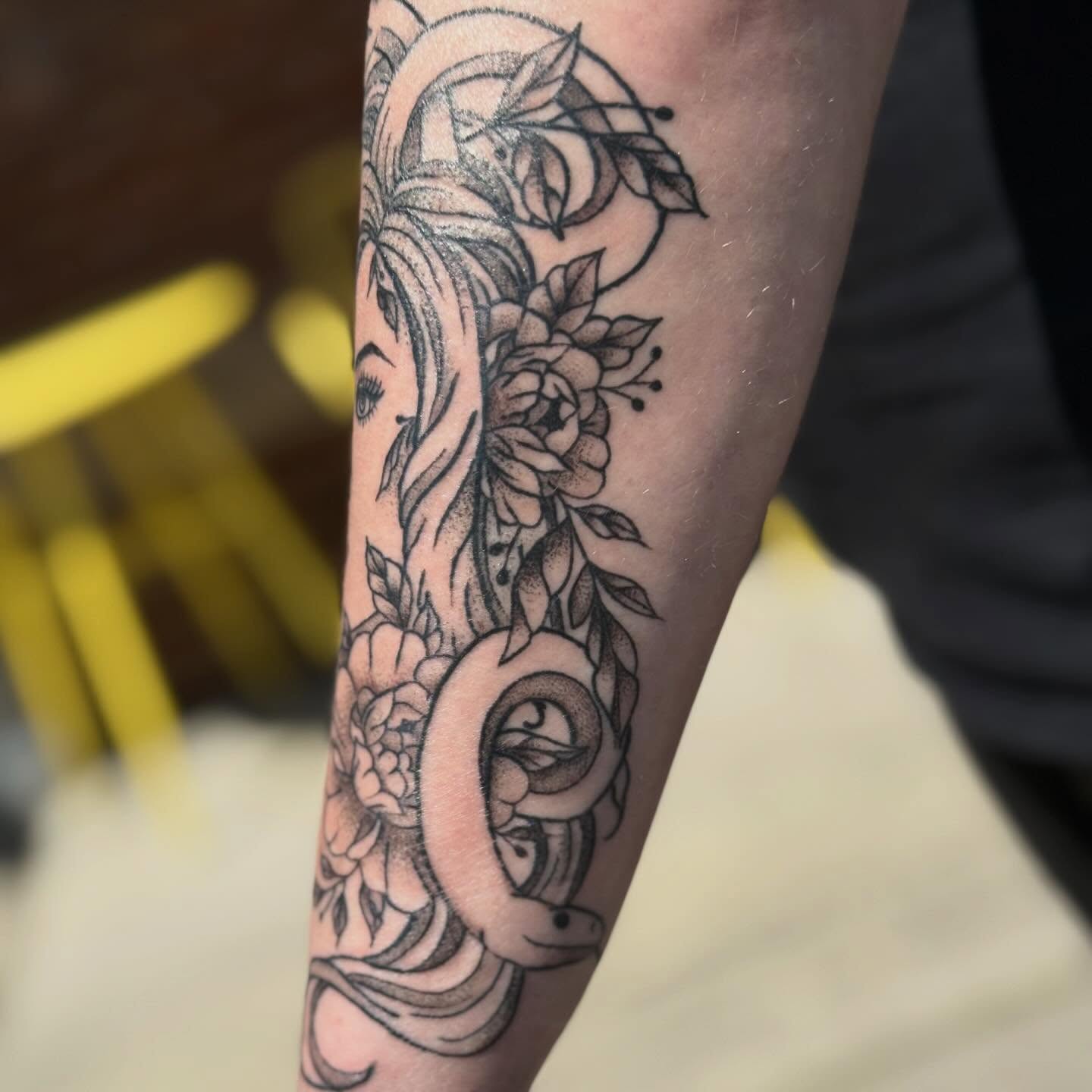 Snake and floral dotwork tattoo on the forearm by zoie rozay hannah