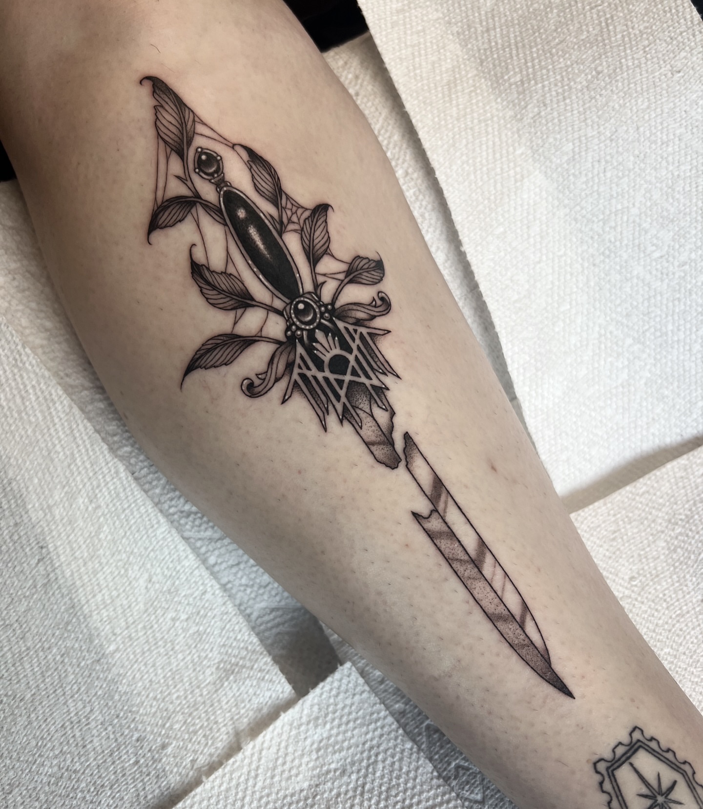 Knife and feathers geometric tattoo on the forearm by ✶ H A N N A H K A y ✶