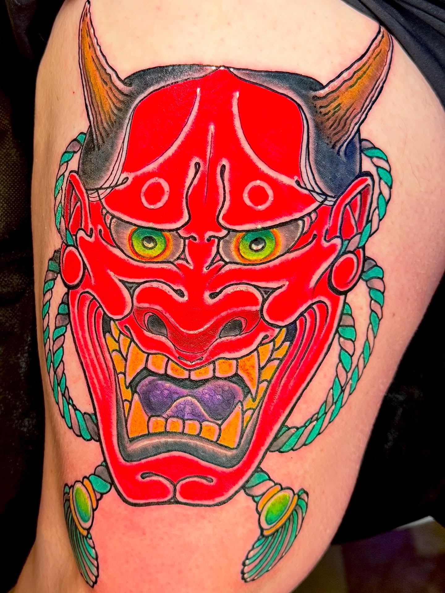 Demon mask American traditional tattoo on the thigh by Dave Robinowitz