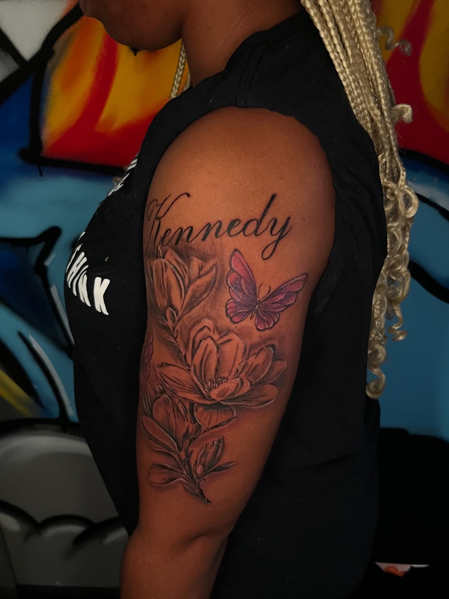 Flower and butterfly realism tattoo on the upper arm by Unknwn Ink ⭐️