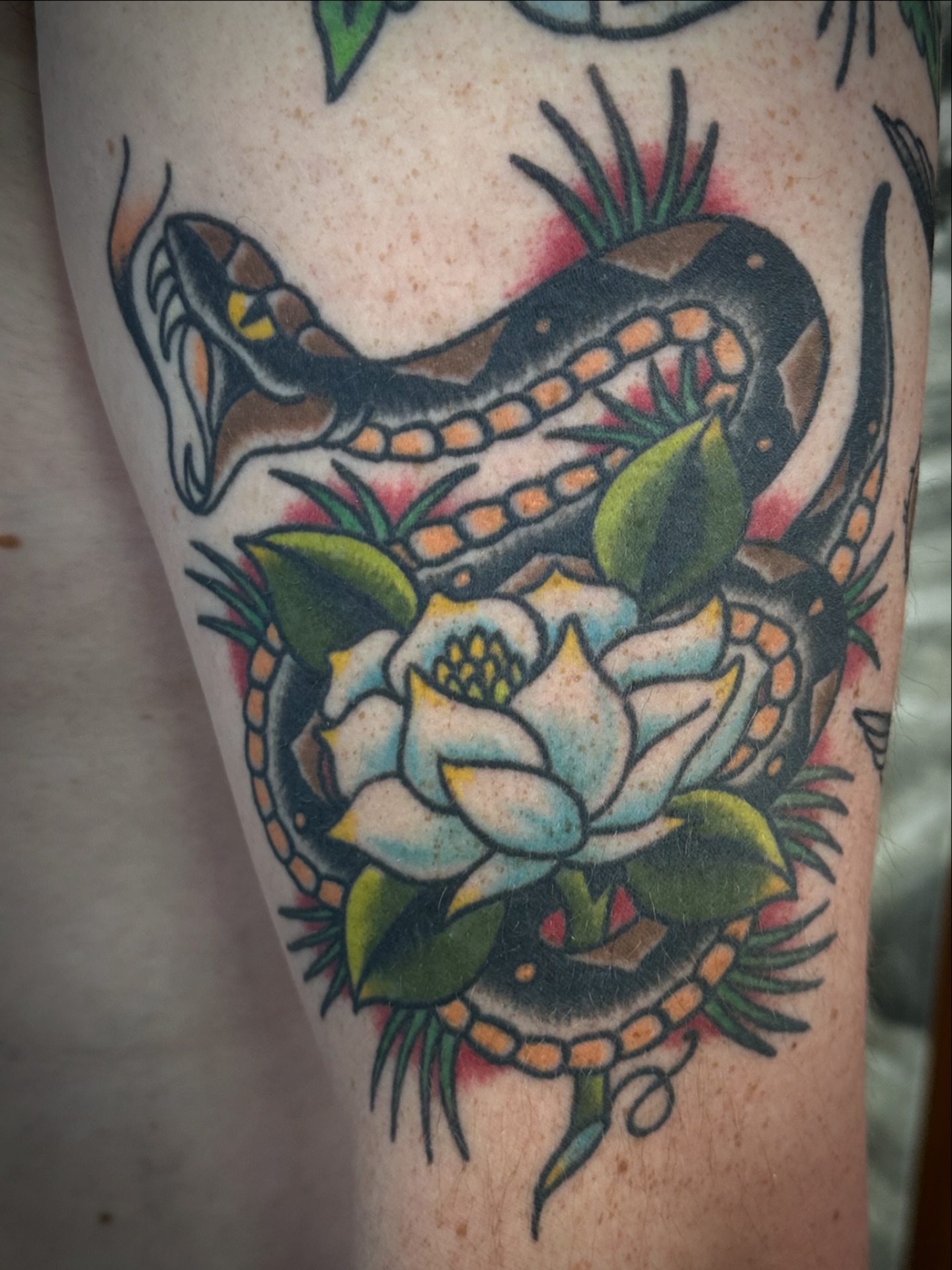 Snake and flower American traditional tattoo on the forearm by Chris Blanchard