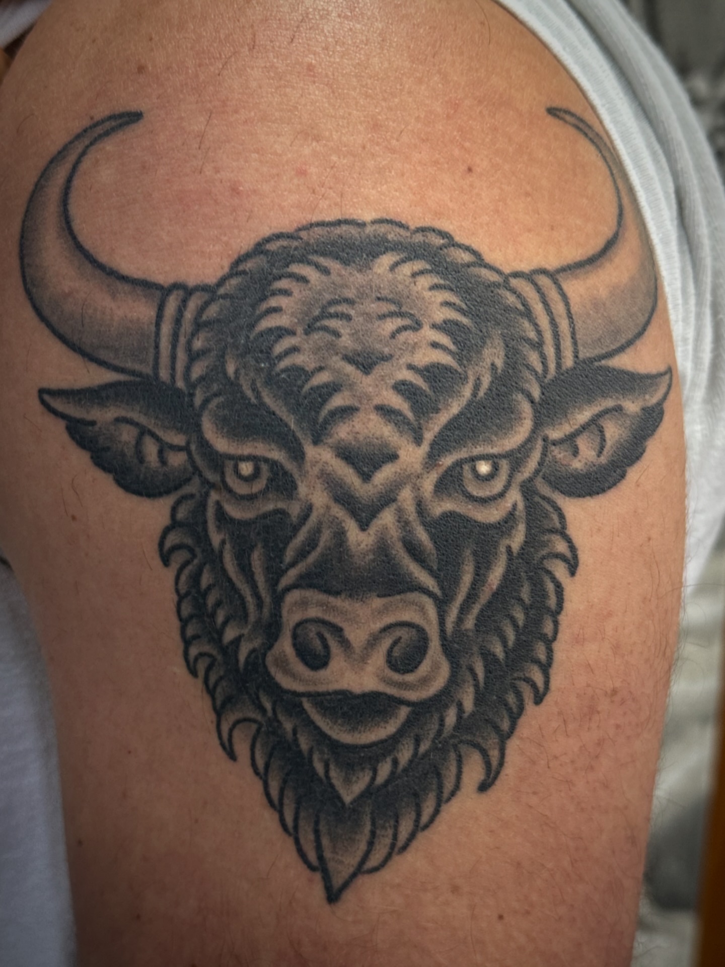 Bull head black and grey tattoo on the shoulder by Chris Blanchard