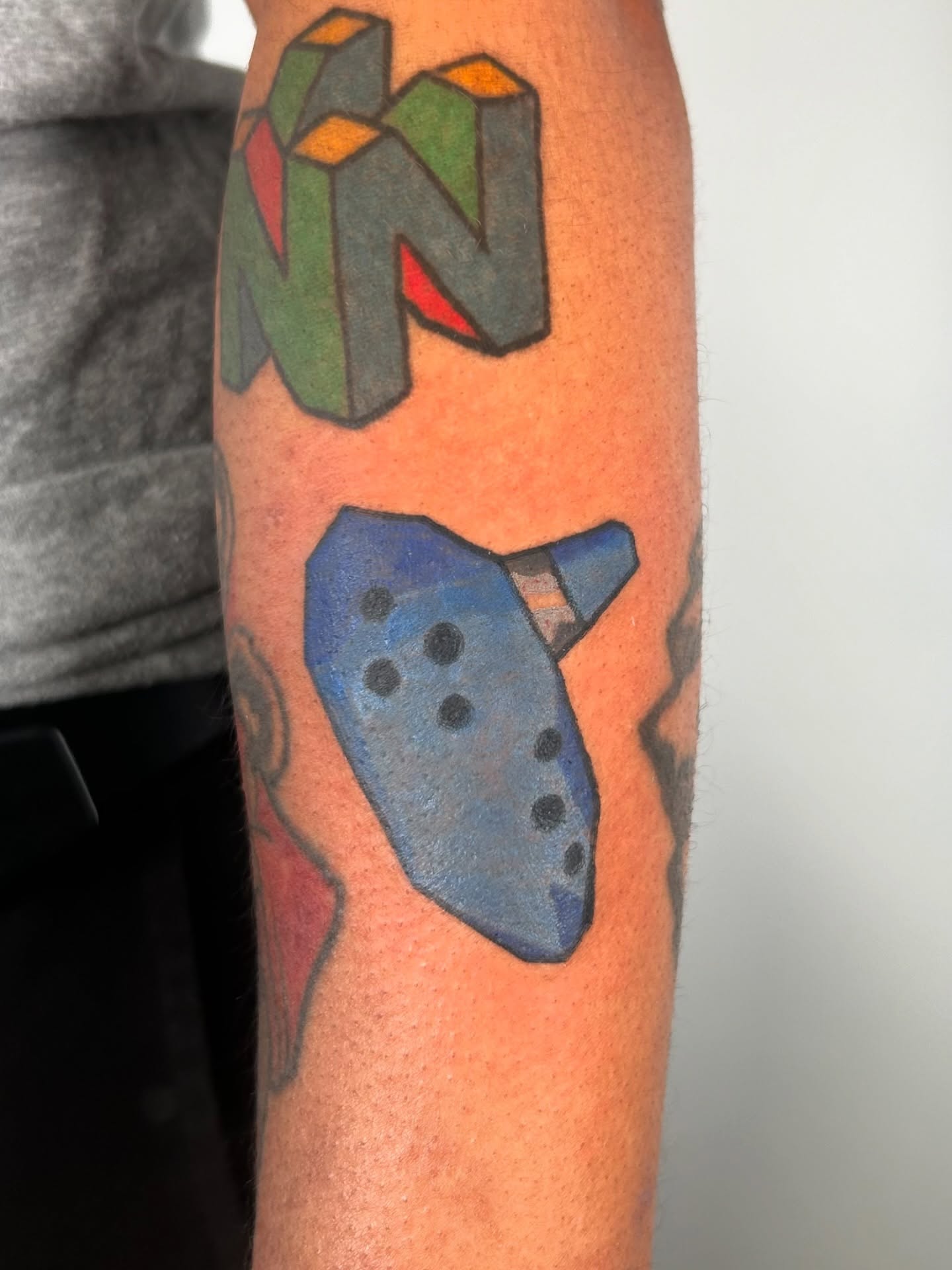 Cube and flute geometric tattoo on the forearm by Ollie
