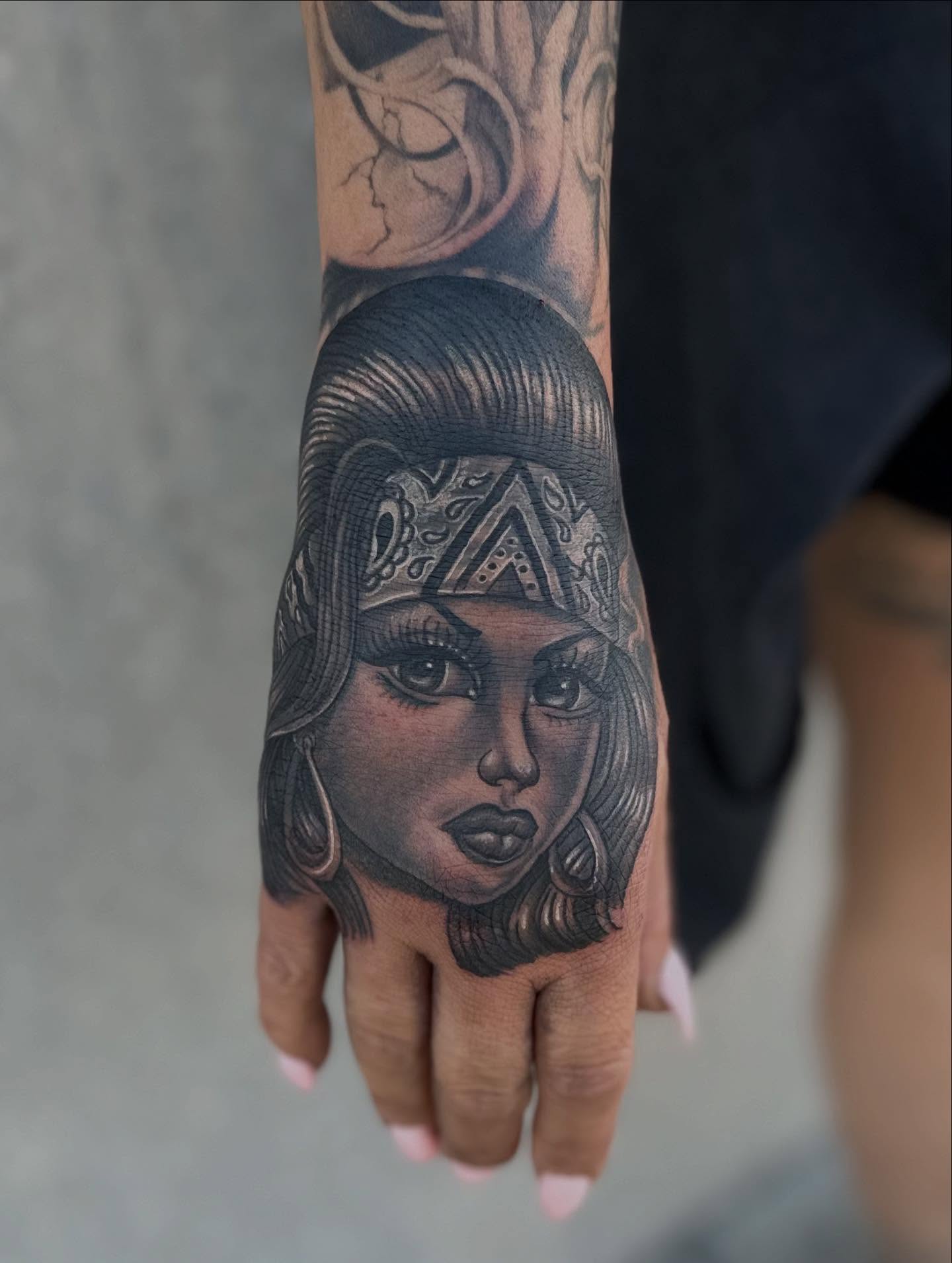 Woman's face realism tattoo on the hand by Ruben