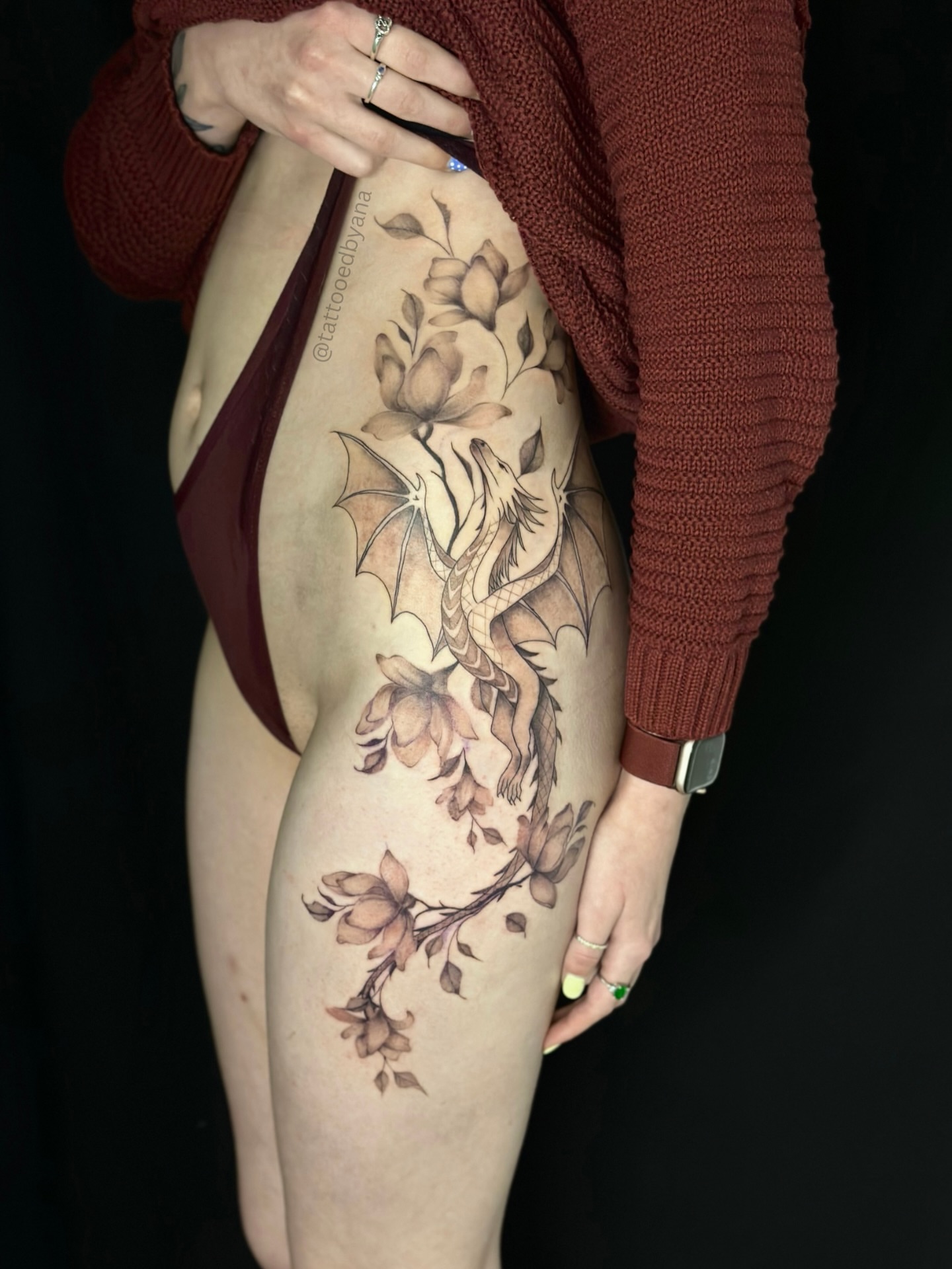 Dragon and flowers black and grey tattoo on the thigh by Tattoo artist Denver