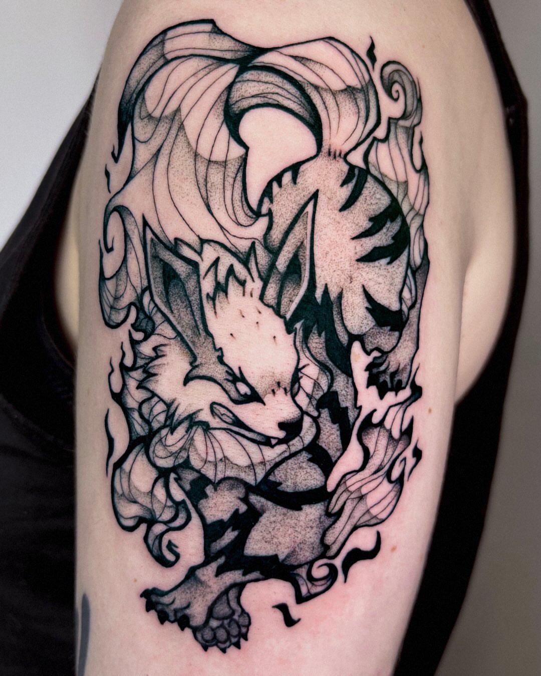 Lion black and grey tattoo on the upper arm by Kal
