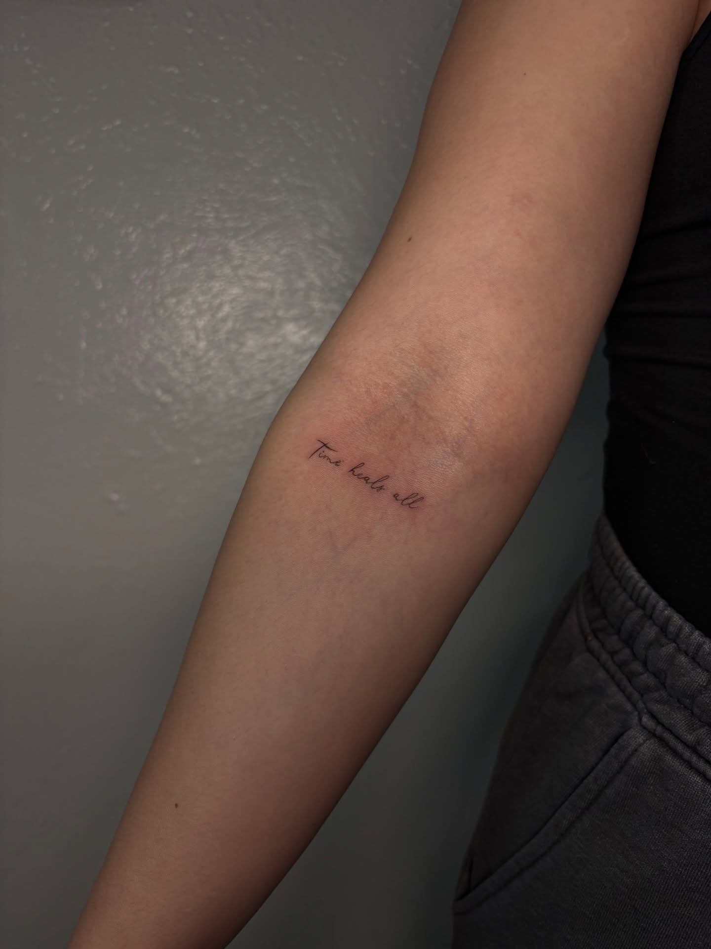 Time heals all lettering script tattoo on the forearm by Valentina