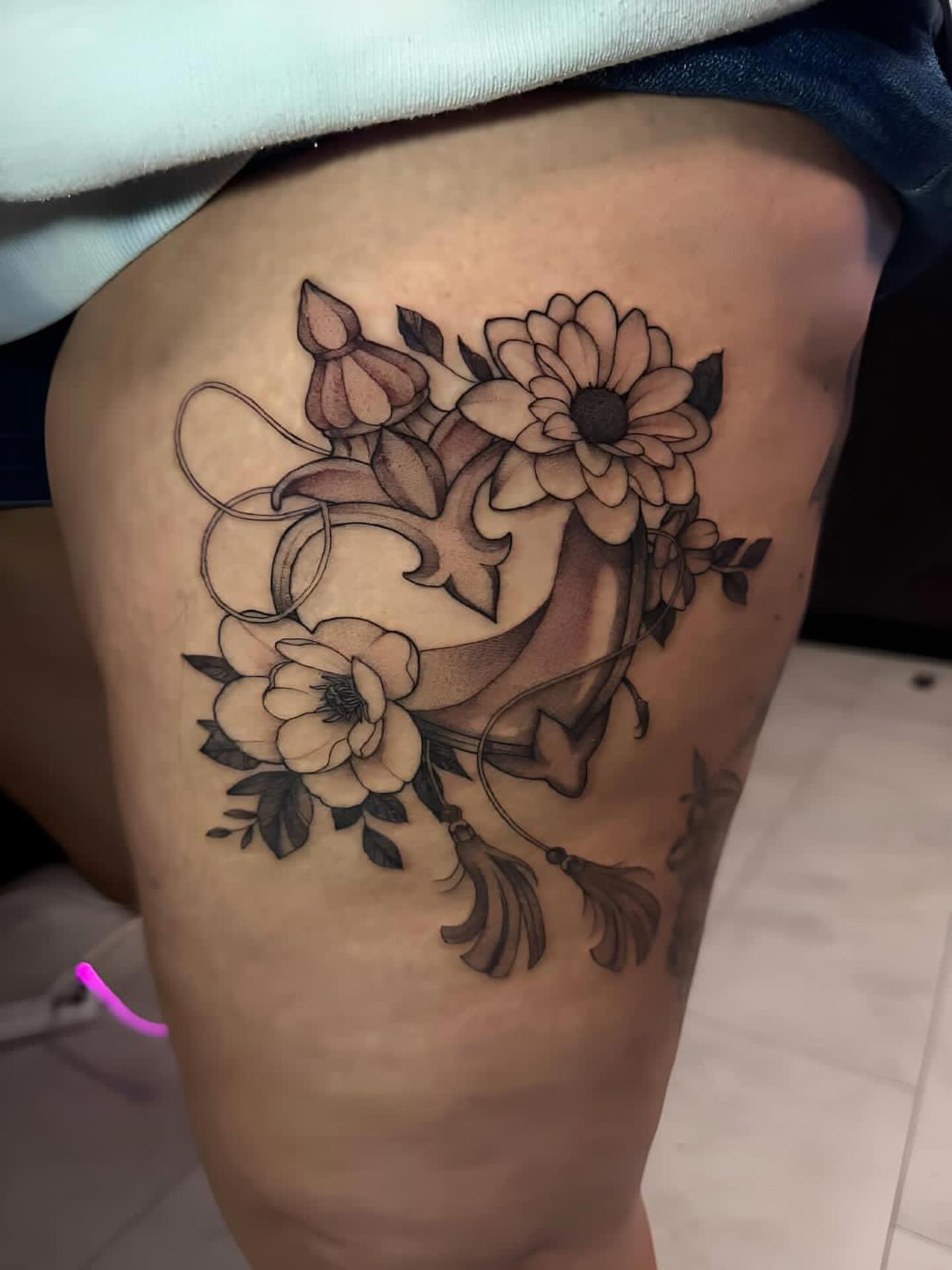 Floral bouquet black and grey tattoo on the thigh by Lindsay