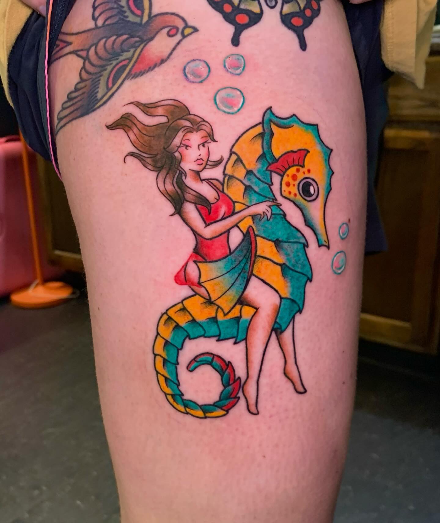 Mermaid riding seahorse American traditional tattoo on the thigh by Hannah Hahn