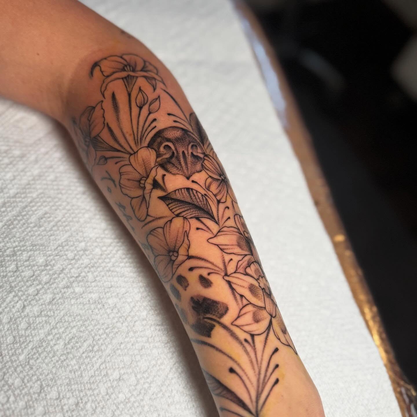 Floral arrangement black and grey tattoo on the forearm by Dylan Walker