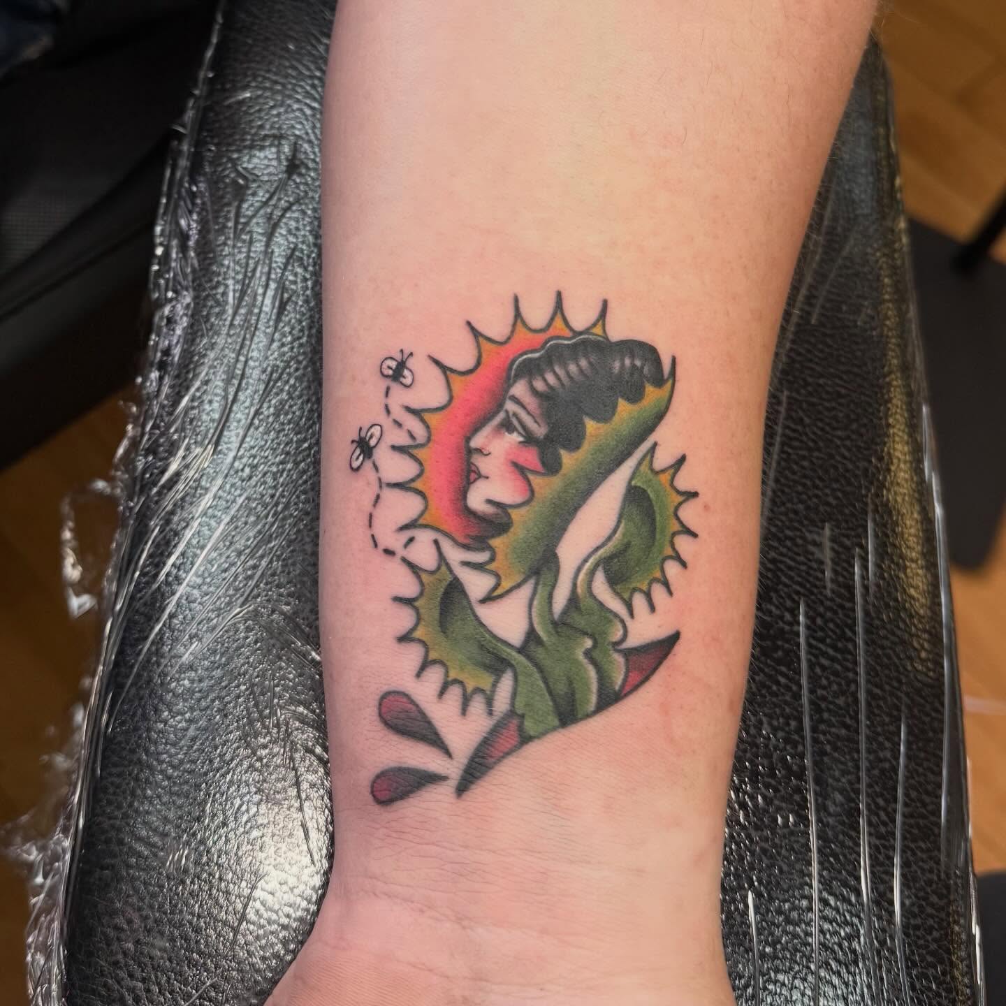 Woman with butterfly American traditional tattoo on the forearm by Nic