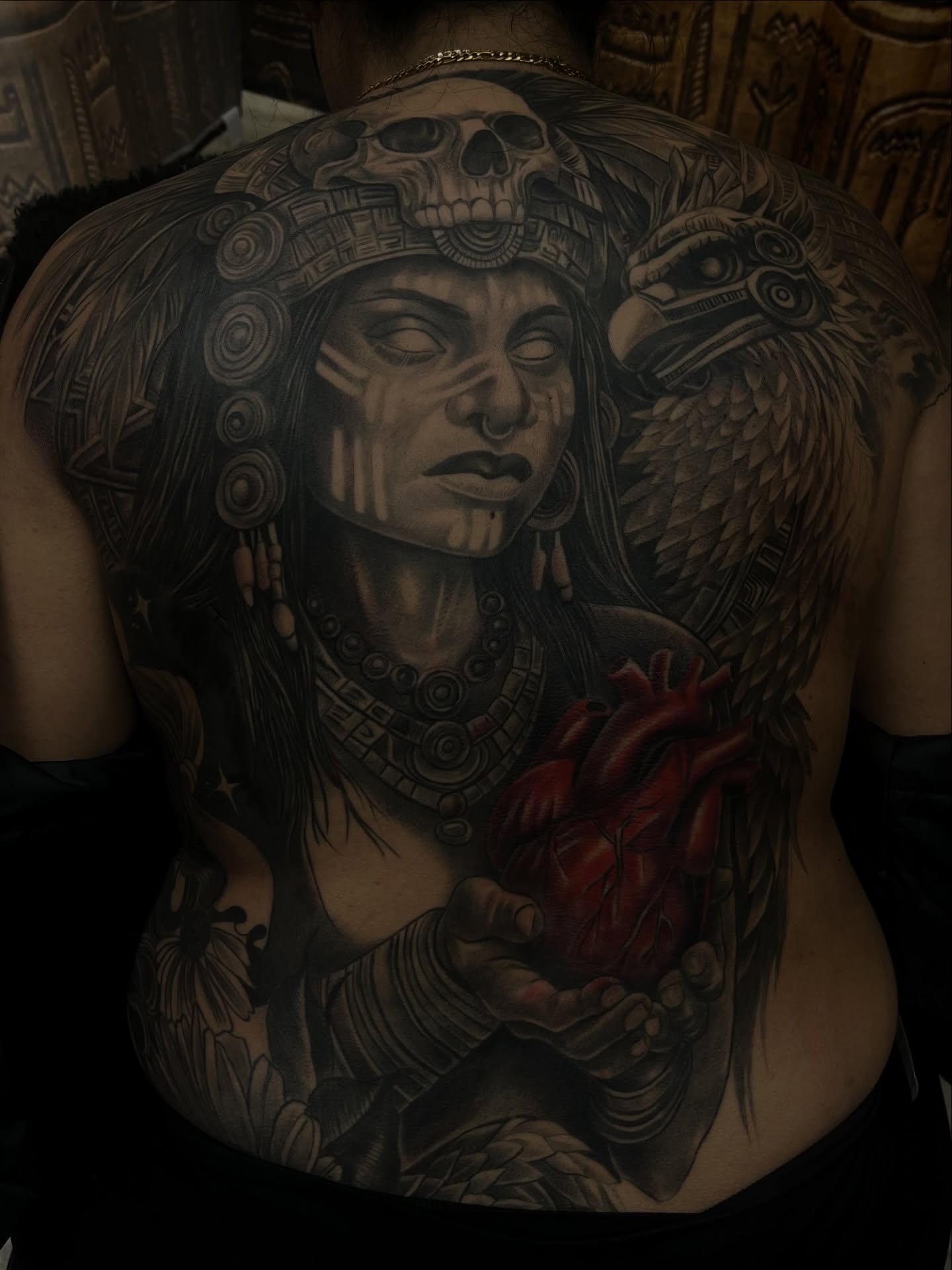 Indigenous woman with heart realism tattoo on the back by Quinten Harper
