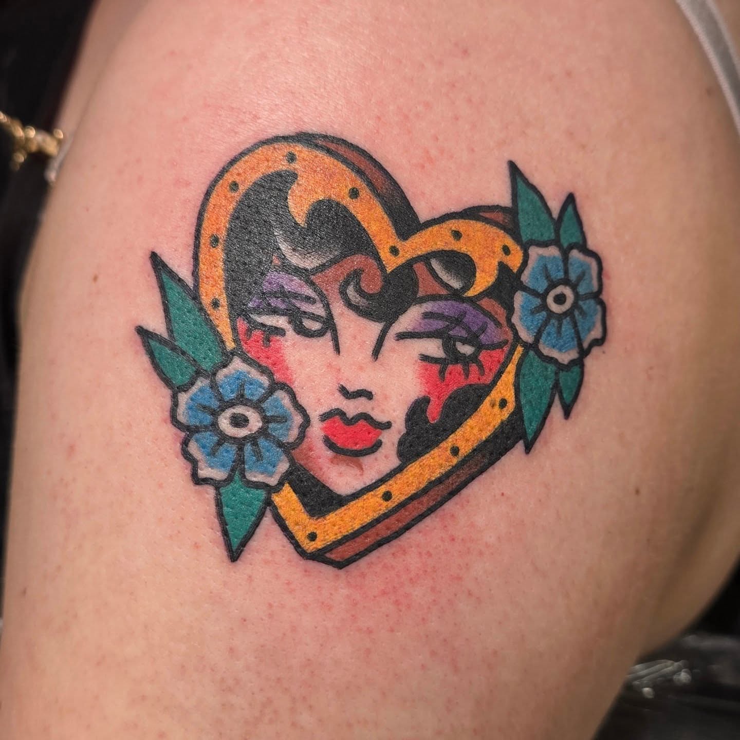 Heart-shaped face American traditional tattoo on the shoulder by A. Teixeira, Los Angeles, California