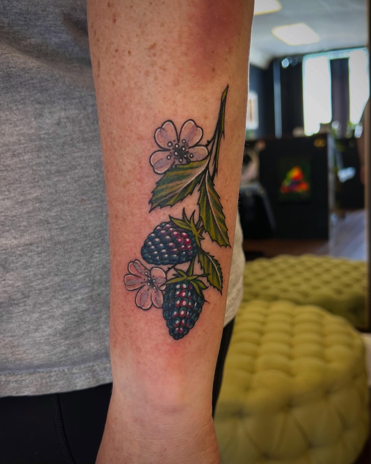 Blackberries and flowers realism tattoo on the forearm by Jon Byrd