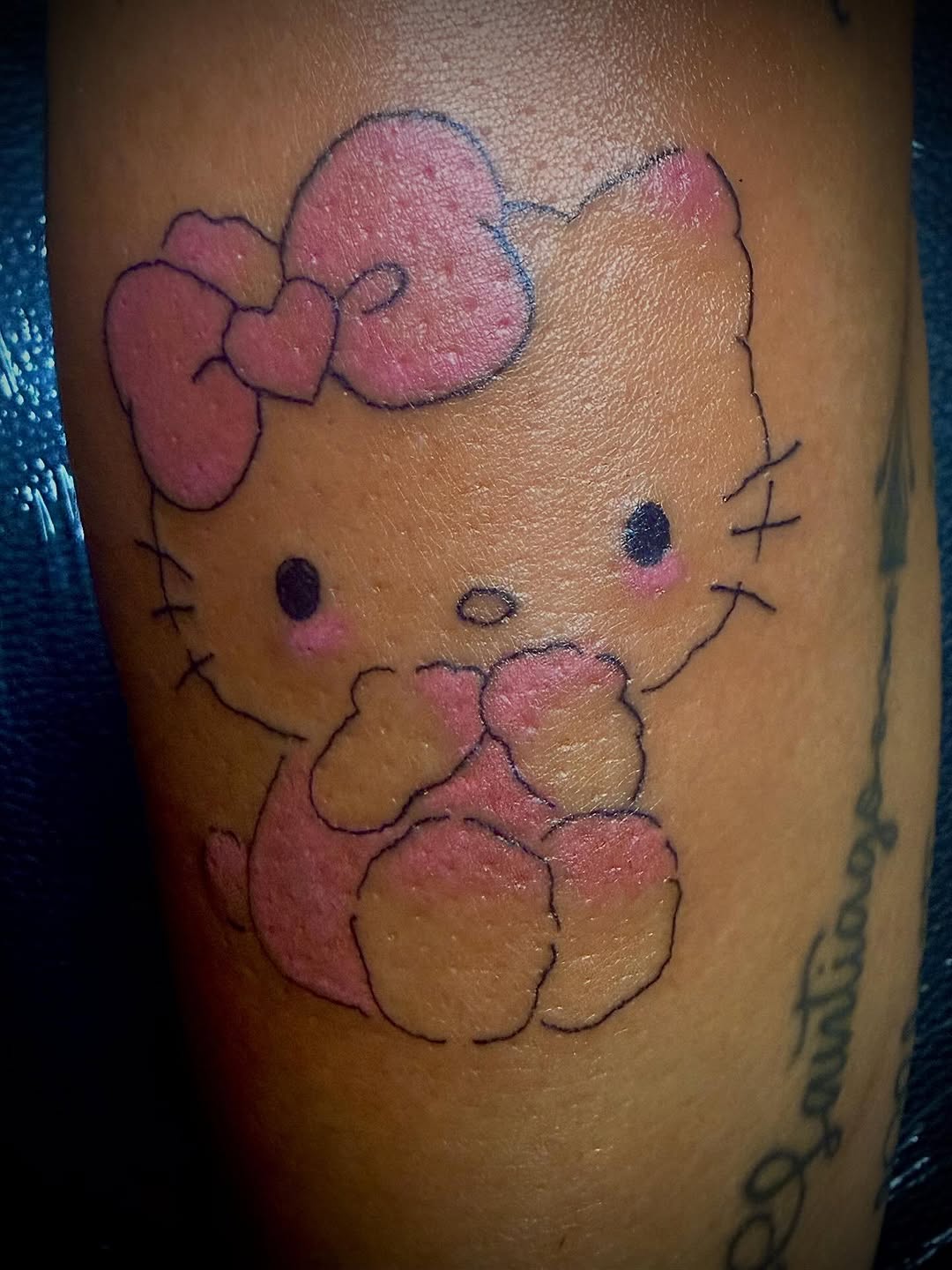 Hello Kitty with a bow tattoo on the forearm by MY$T
